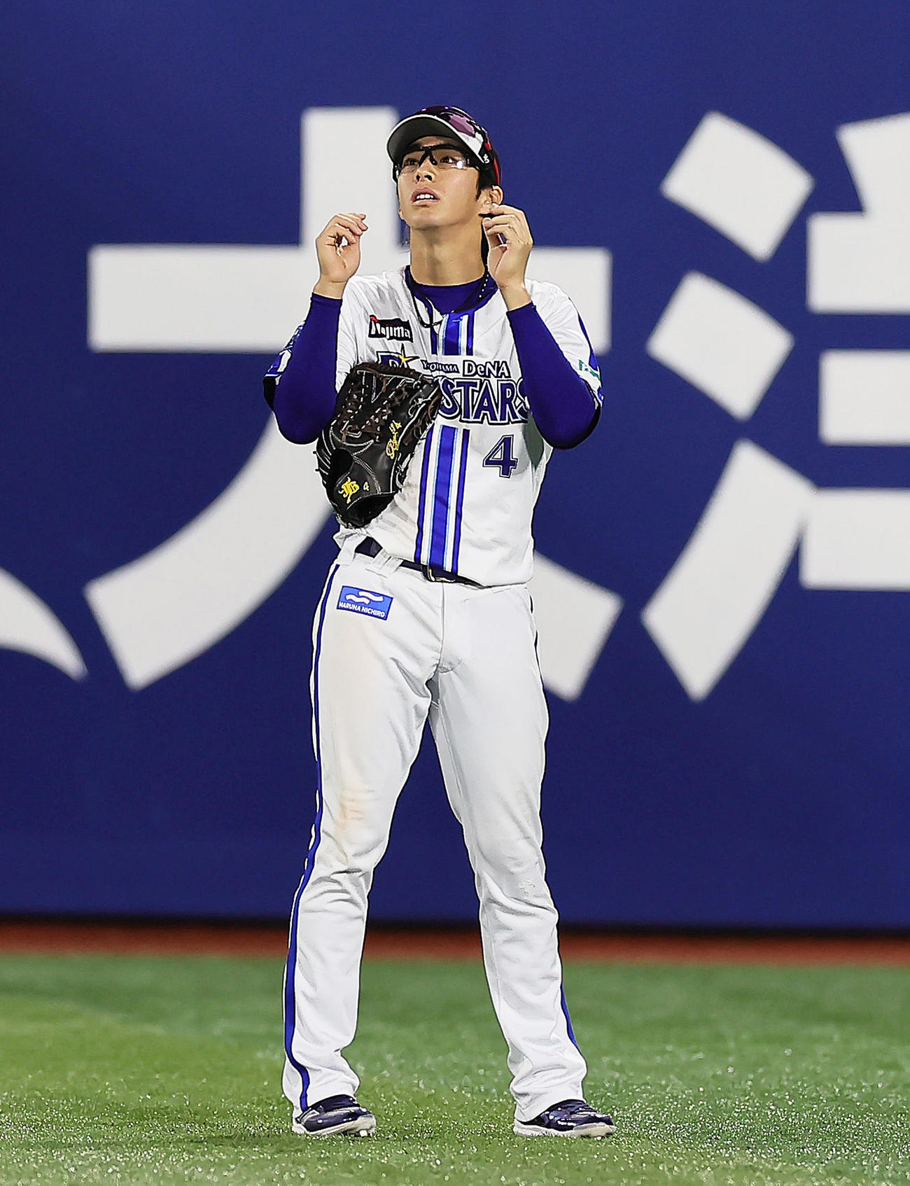 外野守備練習中、サングラスを借りグラウンドの見え方を確認するDeNA度会（撮影・足立雅史）