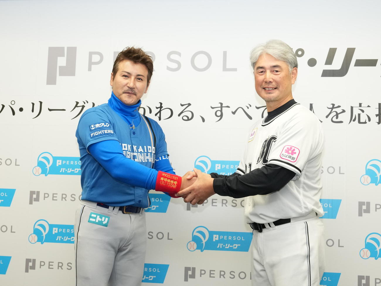 パーソルパ・リーグ2024公式戦の開幕記者会見の記念撮影で握手するロッテ吉井監督（右）と日本ハム新庄監督（撮影・小沢裕）