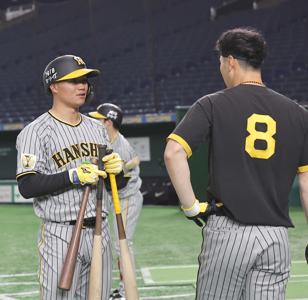 3本のバットを手に佐藤輝（右）と話をする森下（撮影・上田博志）