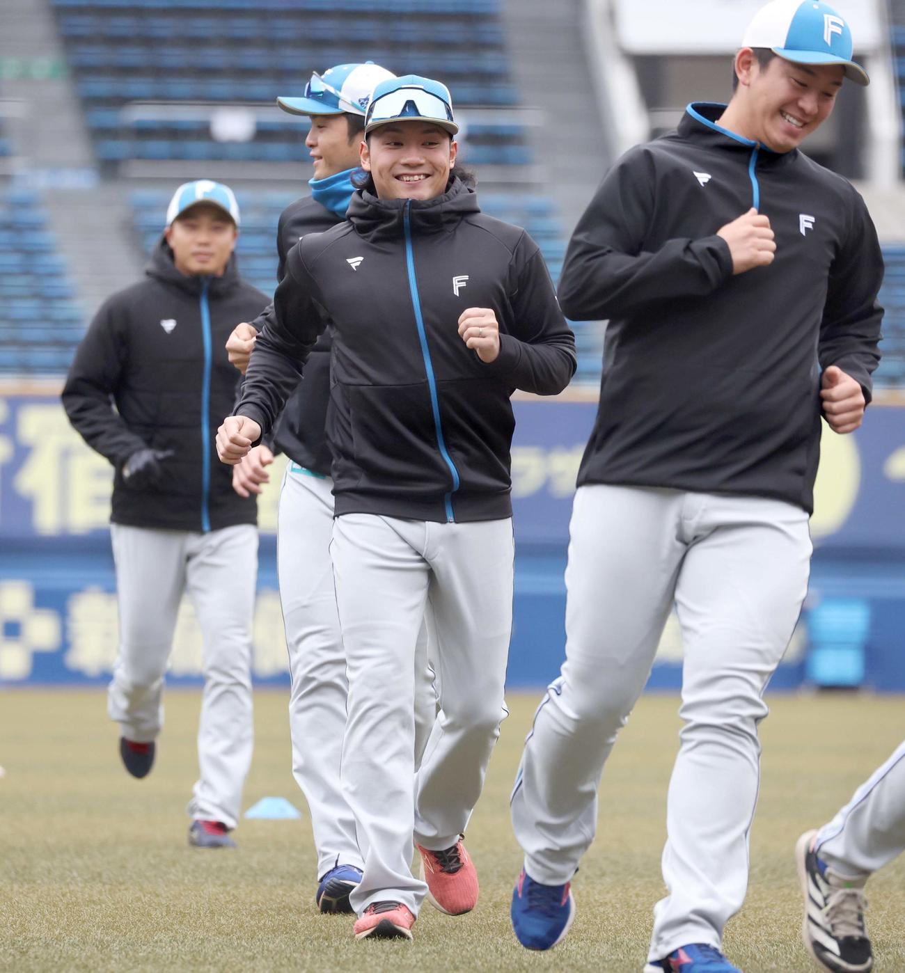 笑顔でアップする日本ハム伊藤（中央）（撮影・黒川智章）