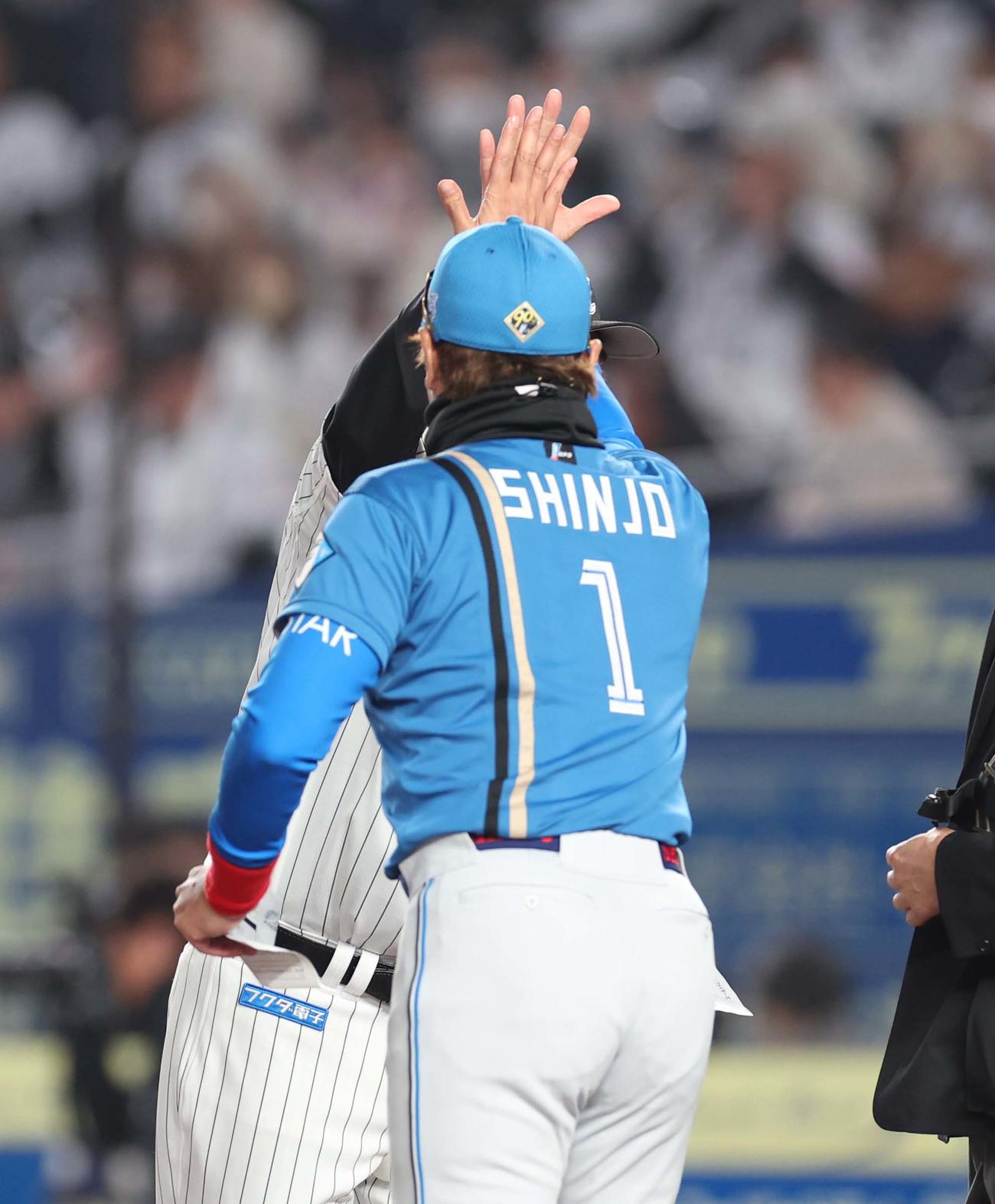 ロッテ対日本ハム　メンバー表交換で吉井監督とハイタッチする新庄監督（撮影・黒川智章）