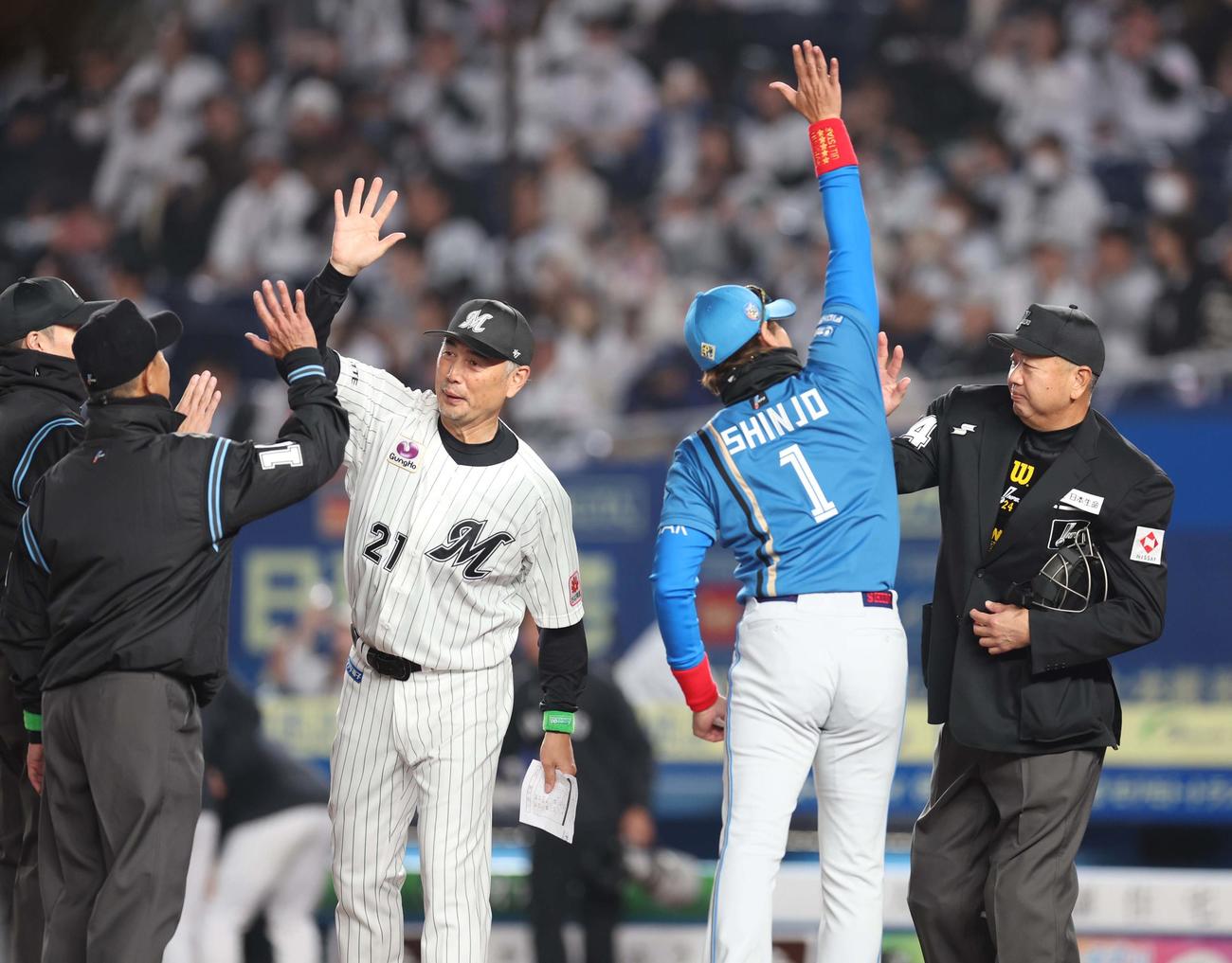 ロッテ対日本ハム　メンバー表交換で審判団ともハイタッチする吉井監督と新庄監督（撮影・黒川智章）