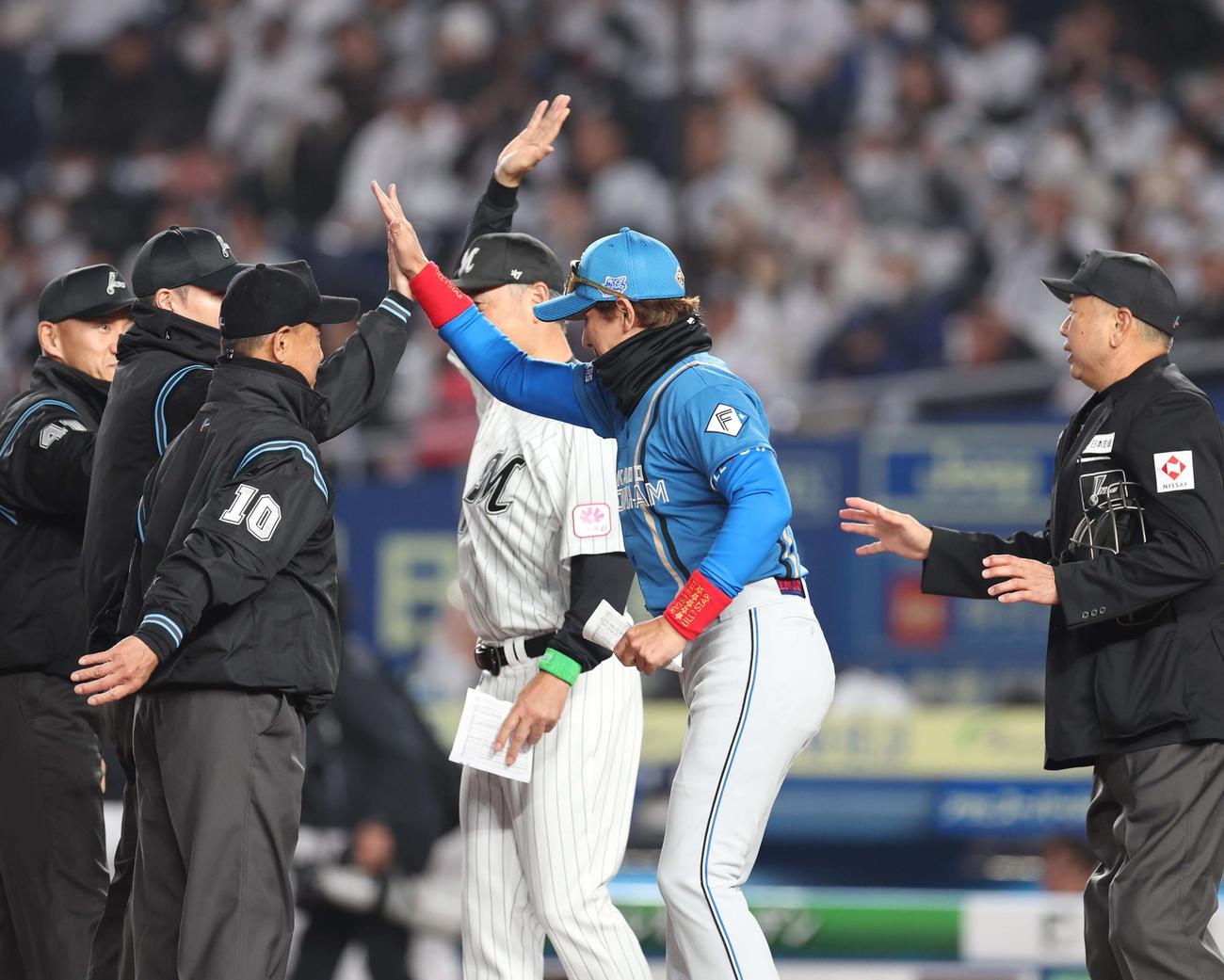ロッテ対日本ハム　メンバー表交換で審判団ともハイタッチする吉井監督と新庄監督（撮影・黒川智章）