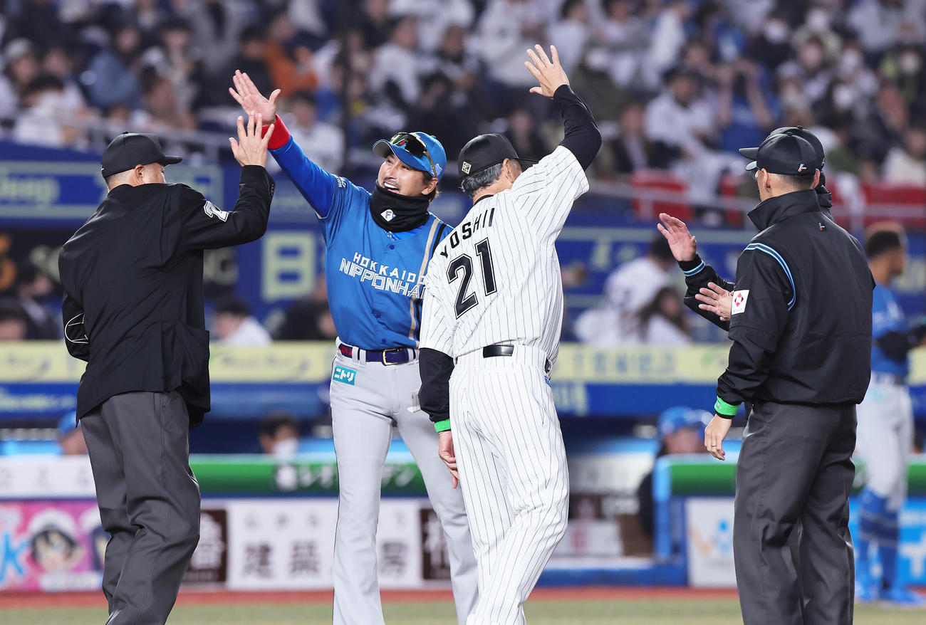 ロッテ対日本ハム　メンバー表交換でハイタッチを交わす日本ハム新庄監督（中央左）とロッテ吉井監督（同右）（撮影・足立雅史）