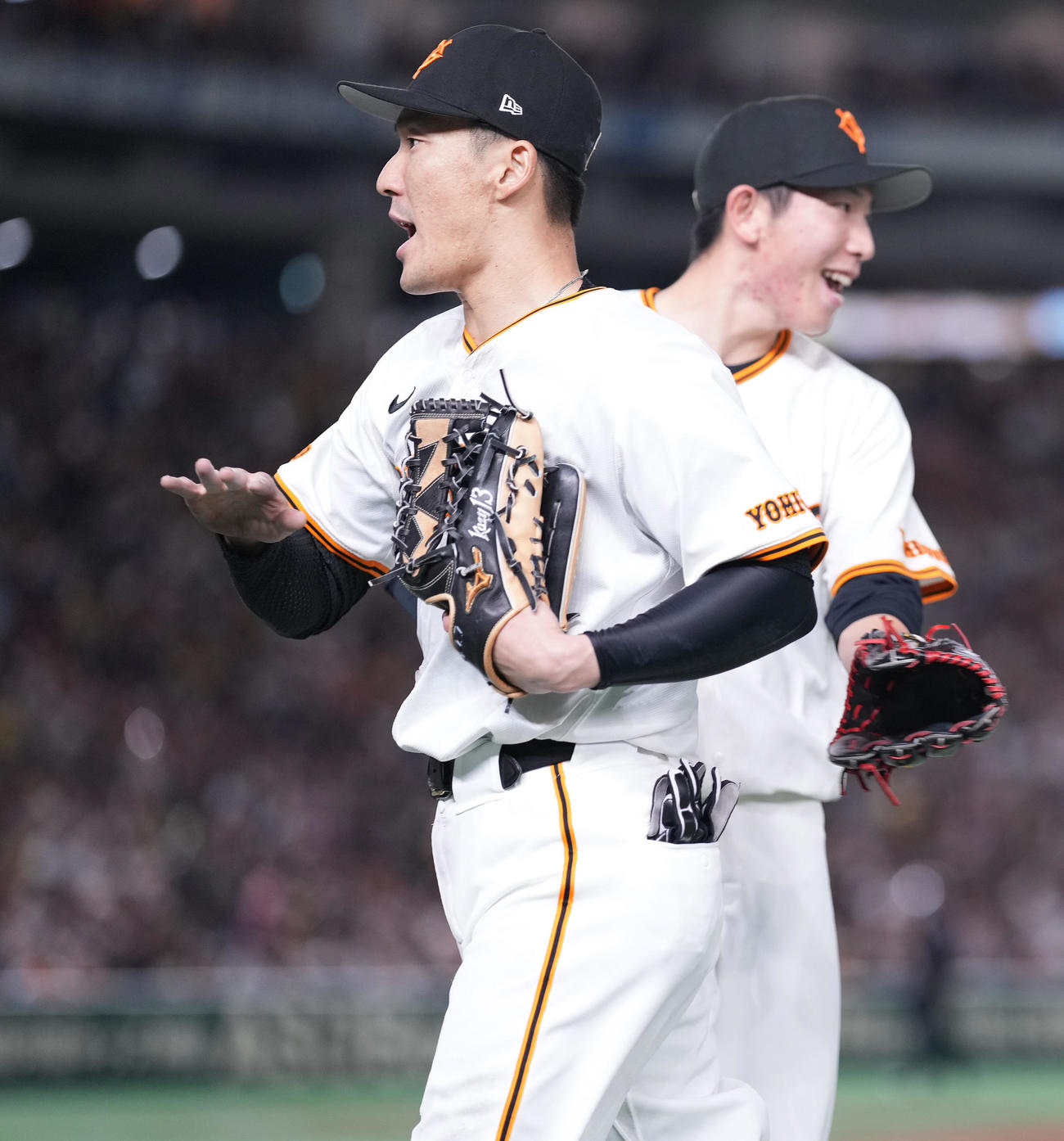 巨人対阪神　3回表に好守をみせた巨人梶谷（左）は戸郷に迎えられベンチへ戻る（撮影・鈴木みどり）