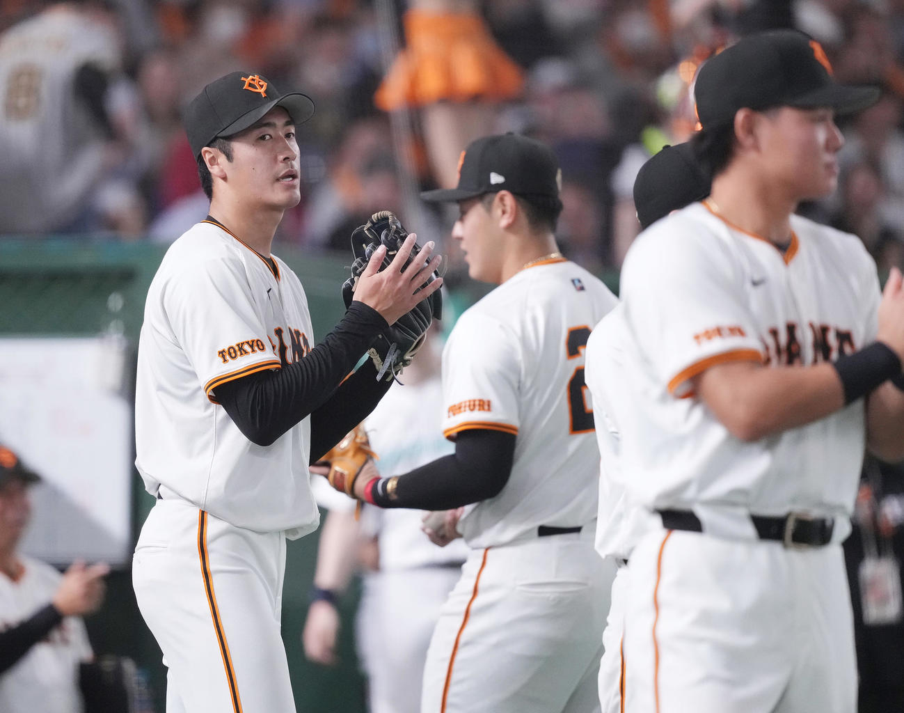 巨人対阪神　7回表を無失点に抑え、ナインを迎える巨人西舘（左）（撮影・鈴木みどり）