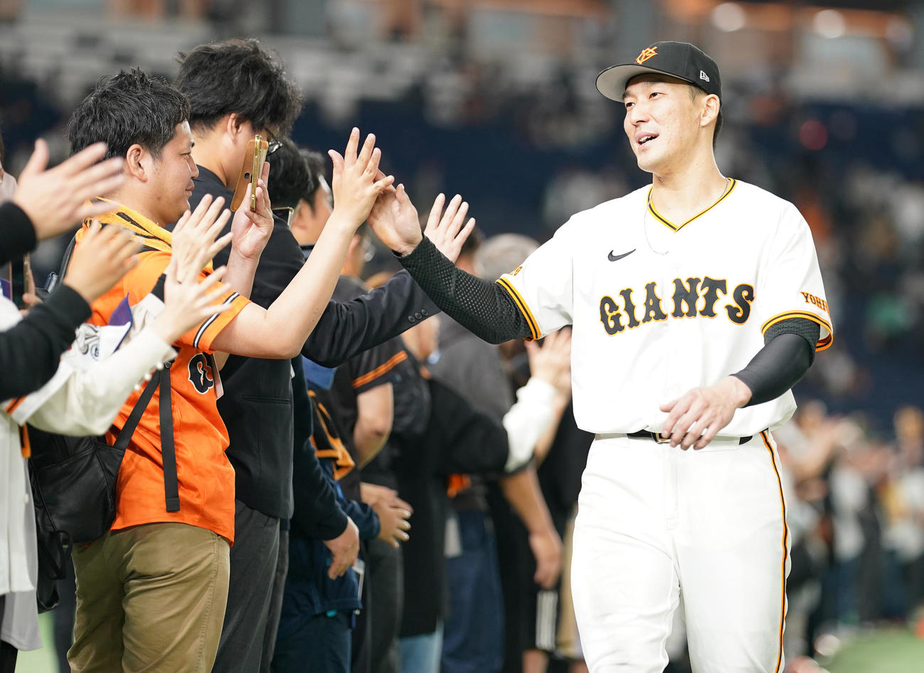 巨人対阪神　阪神に勝利し、ファンとハイタッチする巨人梶谷（撮影・鈴木みどり）