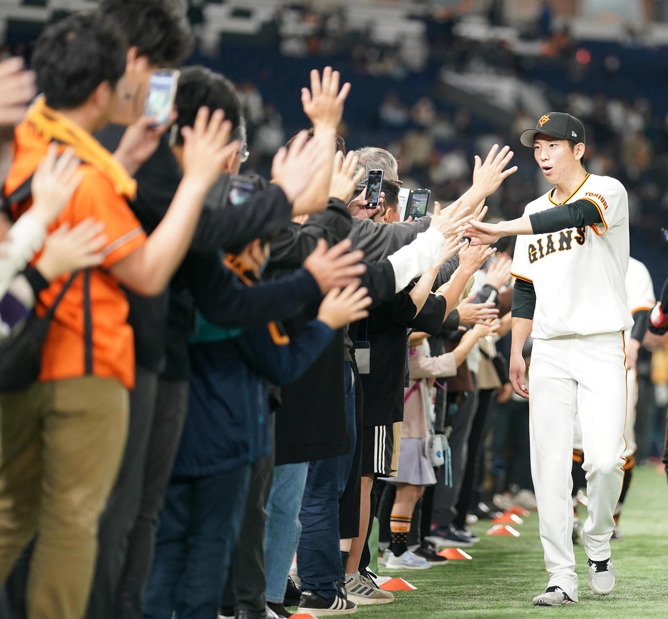 巨人対阪神　阪神に勝利し、ファンとハイタッチする巨人戸郷（撮影・鈴木みどり）