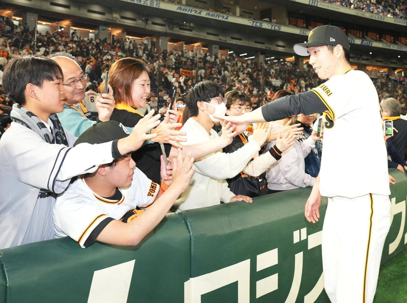 巨人対阪神　阪神に勝利し、ファンとハイタッチする巨人戸郷（撮影・鈴木みどり）