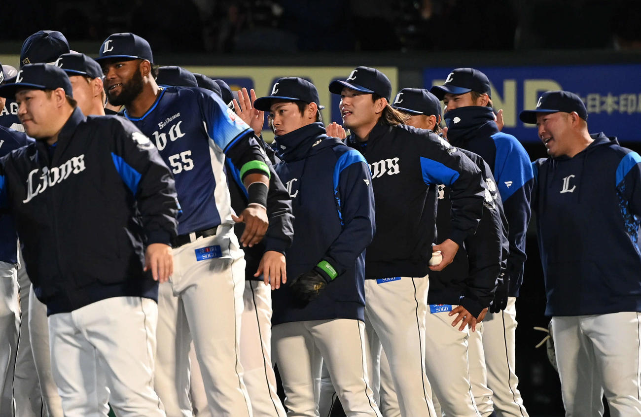 楽天対西武　開幕戦で勝利した西武今井（中央右）は勝利球を手にチームメートとタッチを交わす（撮影・山崎安昭）