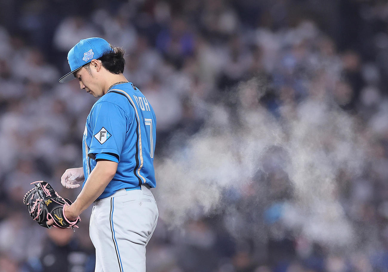 ロッテ対日本ハム　ロジンで手を真っ白にしながら力投する日本ハム伊藤（撮影・足立雅史）