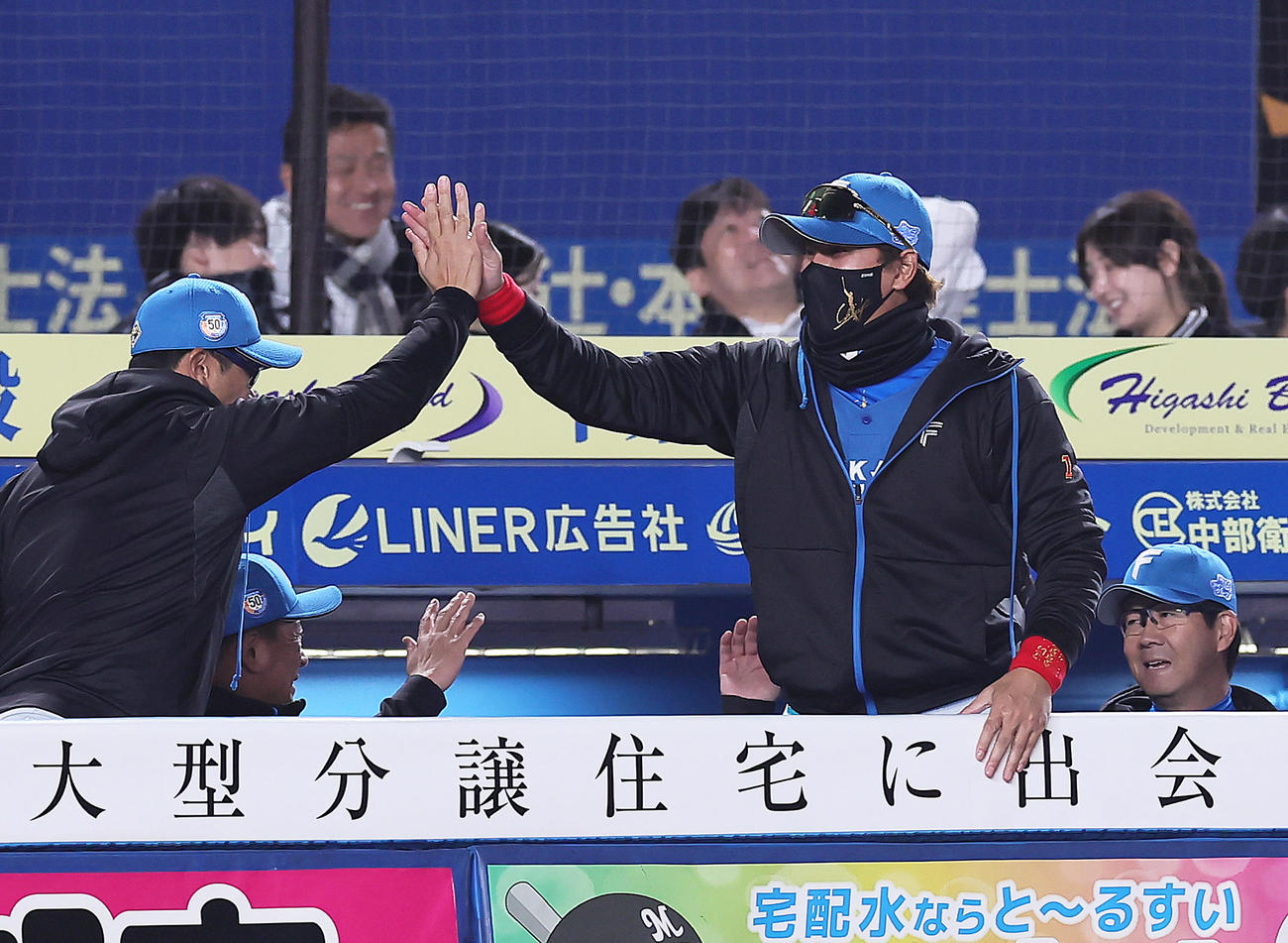 ロッテ対日本ハム　開幕戦に勝利し笑顔でタッチを交わす日本ハム新庄監督（右）（撮影・足立雅史）