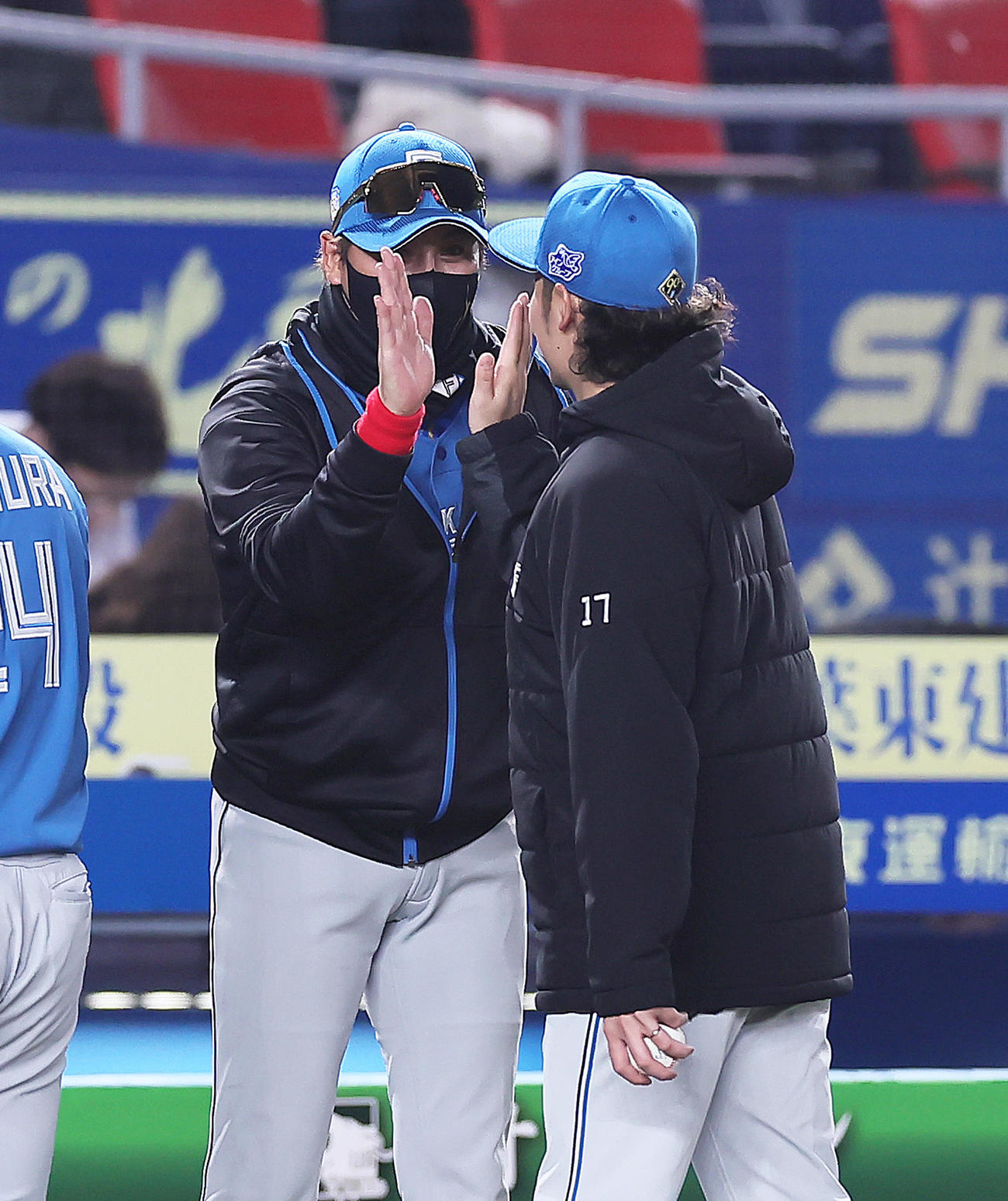 ロッテ対日本ハム　開幕戦に勝利しタッチを交わす日本ハムの新庄監督（左）と伊藤（撮影・足立雅史）