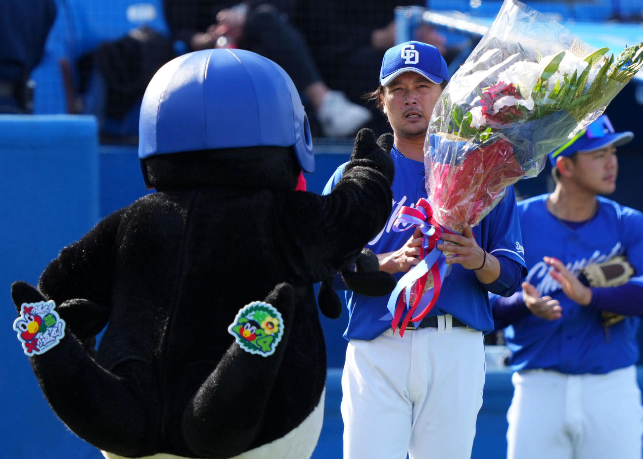 ヤクルト対中日　通算2000奪三振を達成しつば九郎（左）から花束を受け取る涌井（撮影・横山健太）
