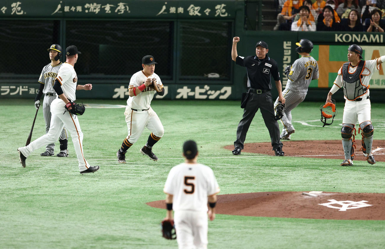 巨人対阪神　4回表阪神1死一、三塁、坂本（左）のセーフティースクイズを一塁手岡本和（中央）が好捕し、三走大山（右から2人目）が帰塁できず併殺となる（撮影・河田真司）