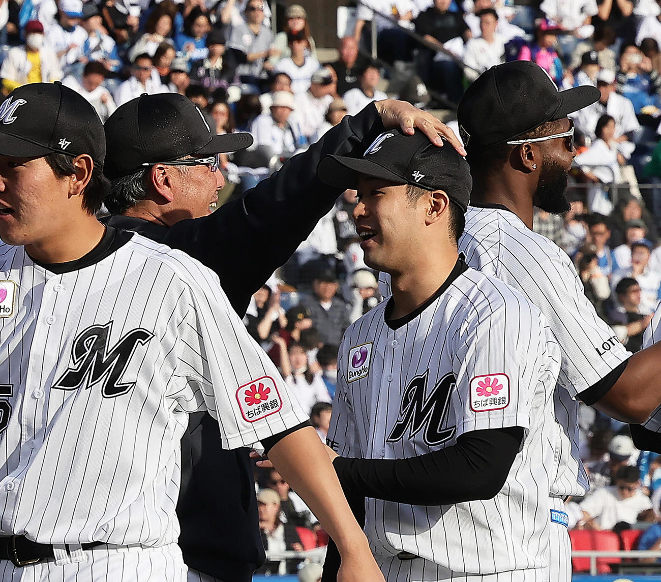 ロッテ対日本ハム　今季初勝利を挙げたロッテ種市（右）は吉井監督に頭をなでられる（撮影・足立雅史）
