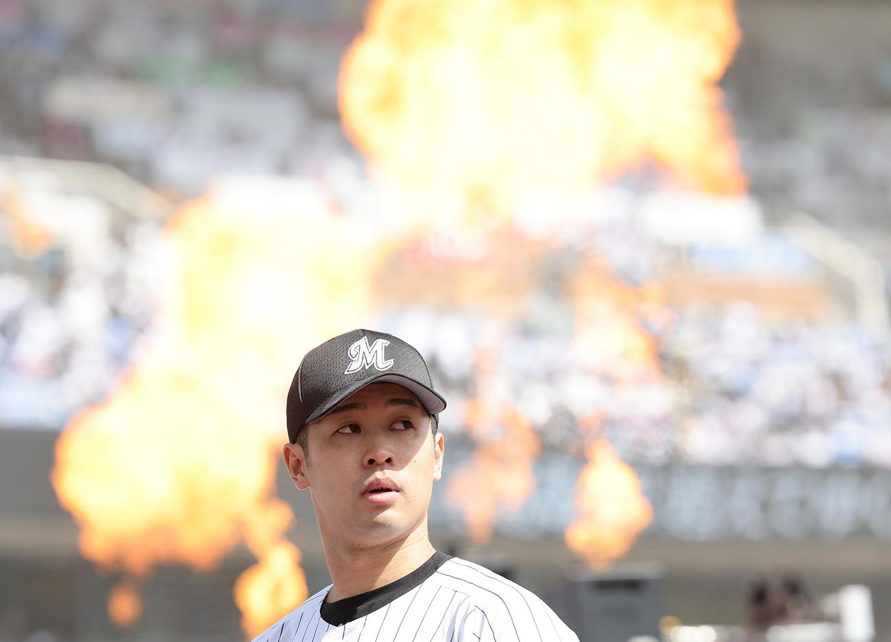 ロッテ対日本ハム　演出で炎が上がる中、登板の準備をするロッテ種市（撮影・足立雅史）
