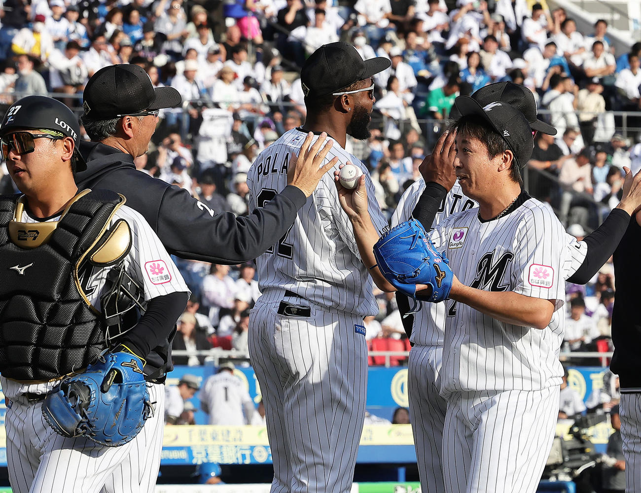 ロッテ対日本ハム　ロッテ吉井監督（左から2人目）に勝利球を渡そうとするも受け取ってもらえず苦笑いする益田（右）（撮影・足立雅史）
