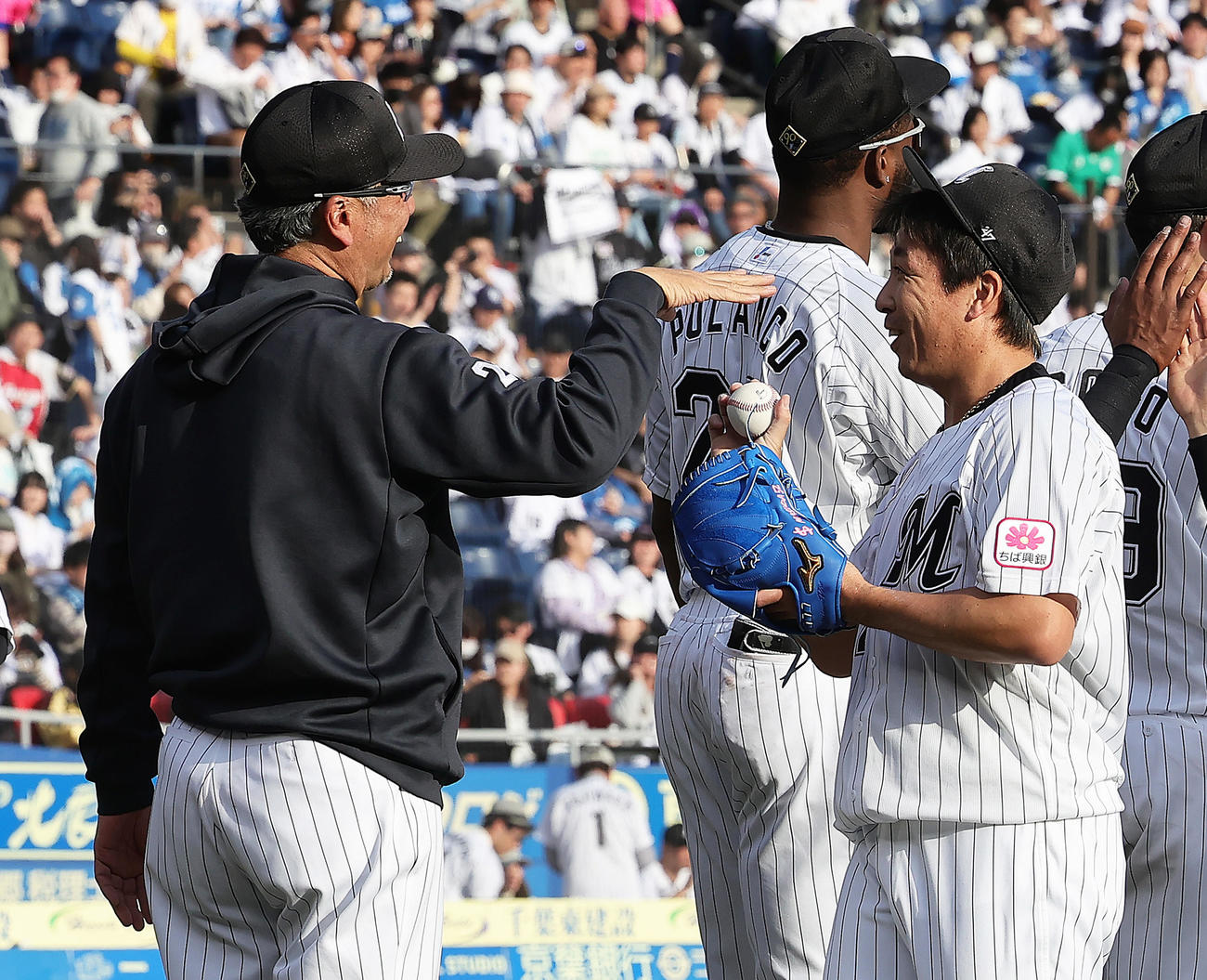 ロッテ対日本ハム　ロッテ吉井監督（左）に勝利球を渡そうとするも受け取ってもらえず苦笑いする益田（撮影・足立雅史）