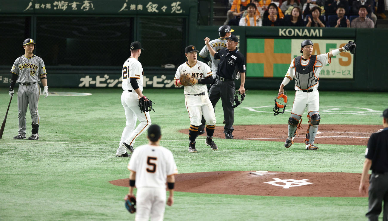 巨人対阪神　4回表阪神1死一、三塁、坂本（左）のセーフティースクイズを一塁手岡本和（中央）が好捕し、三走大山（奥）が帰塁できず併殺となる（撮影・河田真司）