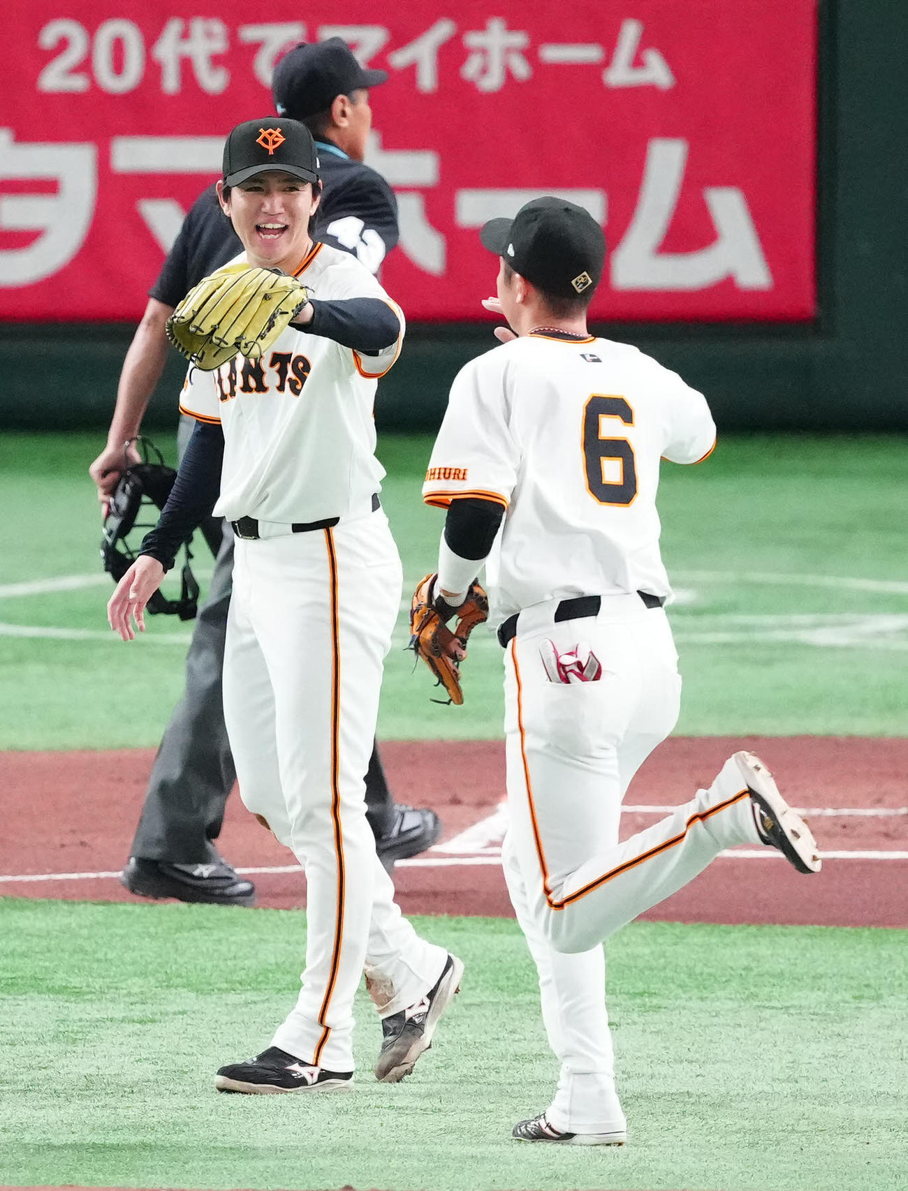 巨人対阪神　1回表終了後、巨人三塁手坂本（右）とタッチを交わす先発の高橋礼（撮影・江口和貴）