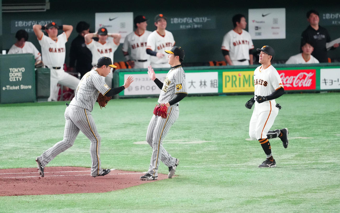 巨人対阪神　6回裏巨人2死一、三塁、一ゴロとなった代打梶谷（右）の打球を好守した一塁手大山（左）とタッチを交わす才木（撮影・江口和貴）