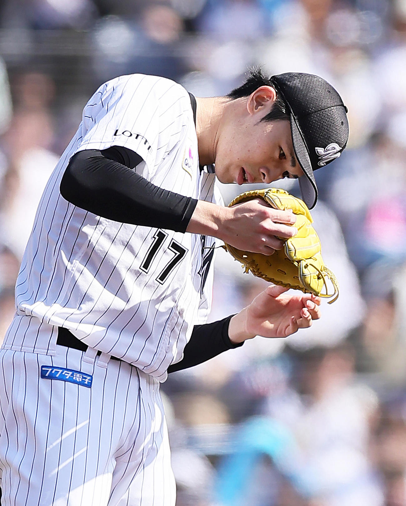 ロッテ対日本ハム　3回、マウンドでバランスを崩したロッテ佐々木はグラブについた砂を落とす（撮影・足立雅史）
