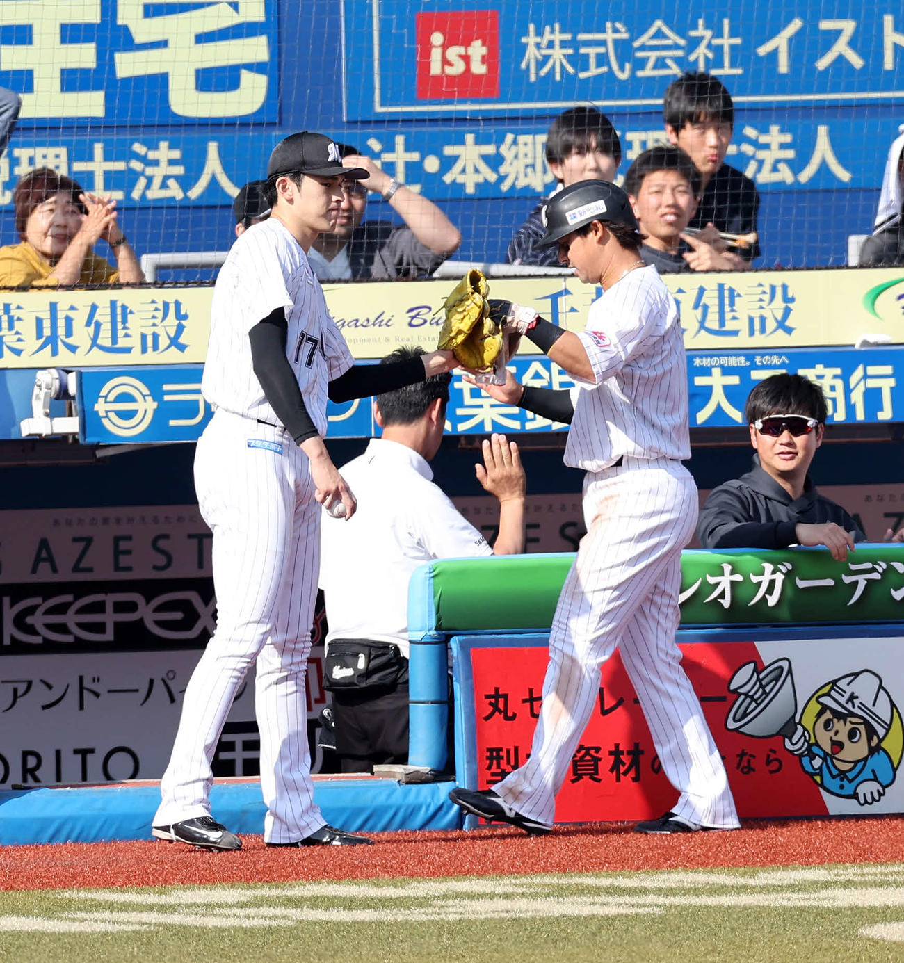 ロッテ対日本ハム　3 3回裏ロッテ1死一、三塁、山口の遊内野適時打で生還した藤岡（右）とタッチする佐々木（撮影・鈴木正人）