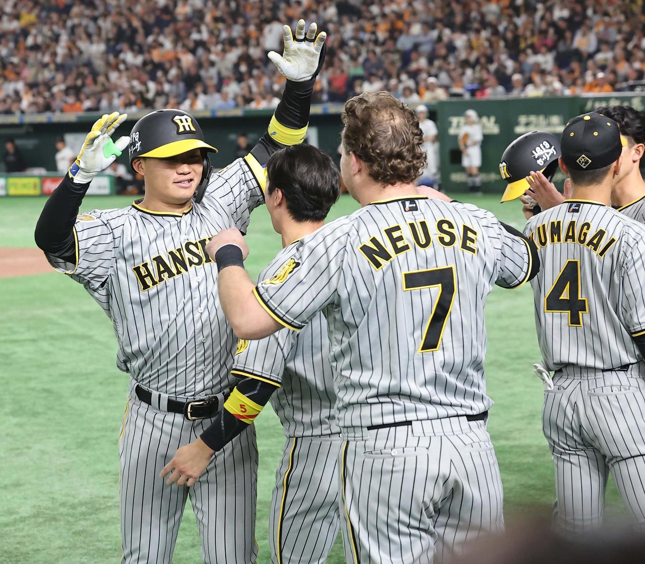 巨人対阪神　8回表阪神2死一、三塁、森下（左）は左中間へ先制3点本塁打を放ちナインの出迎えを受ける（撮影・上田博志）