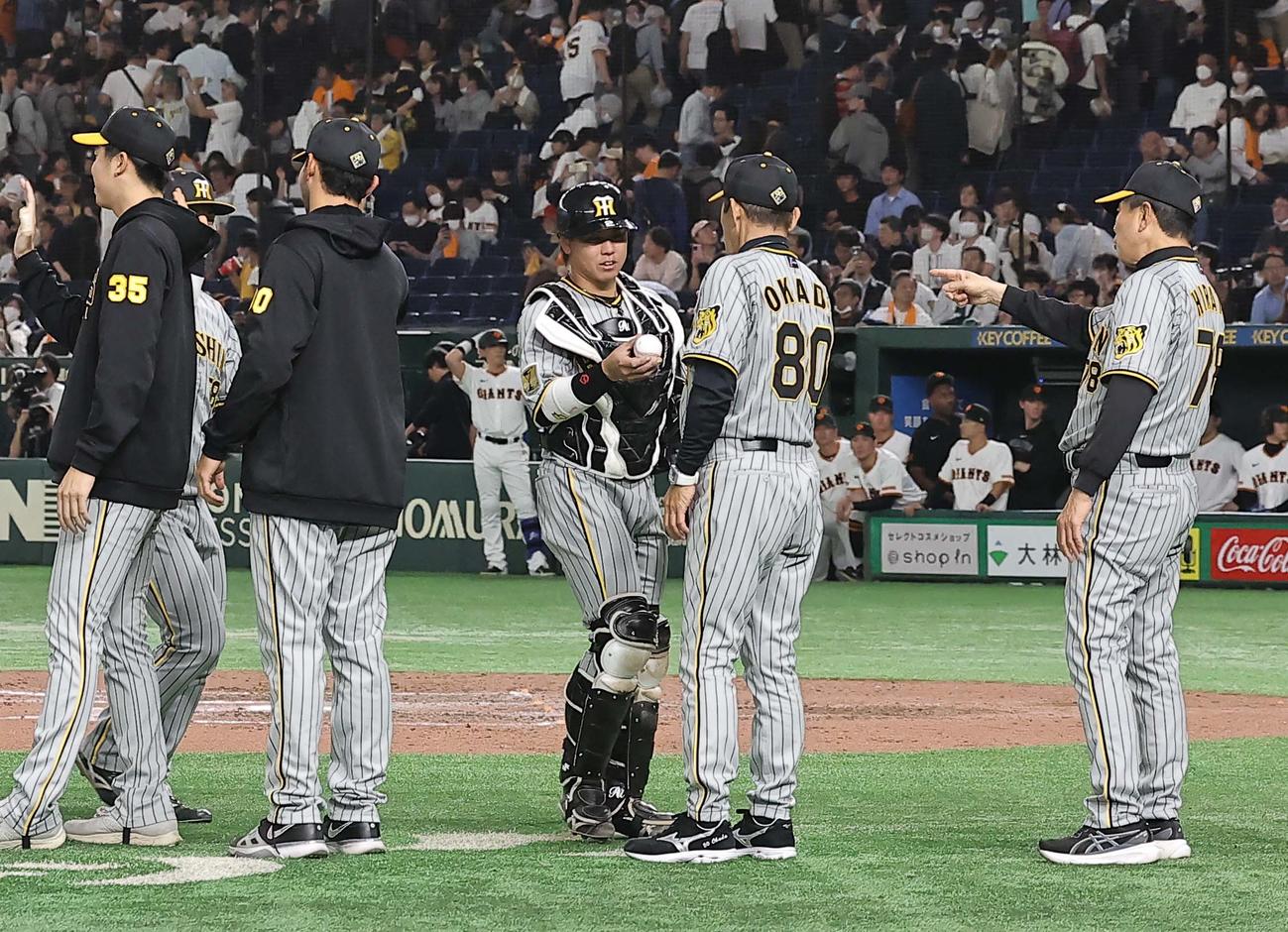 巨人対阪神　梅野隆太郎（中央左）は岡田彰布監督に勝利球を手渡す（撮影・上田博志）