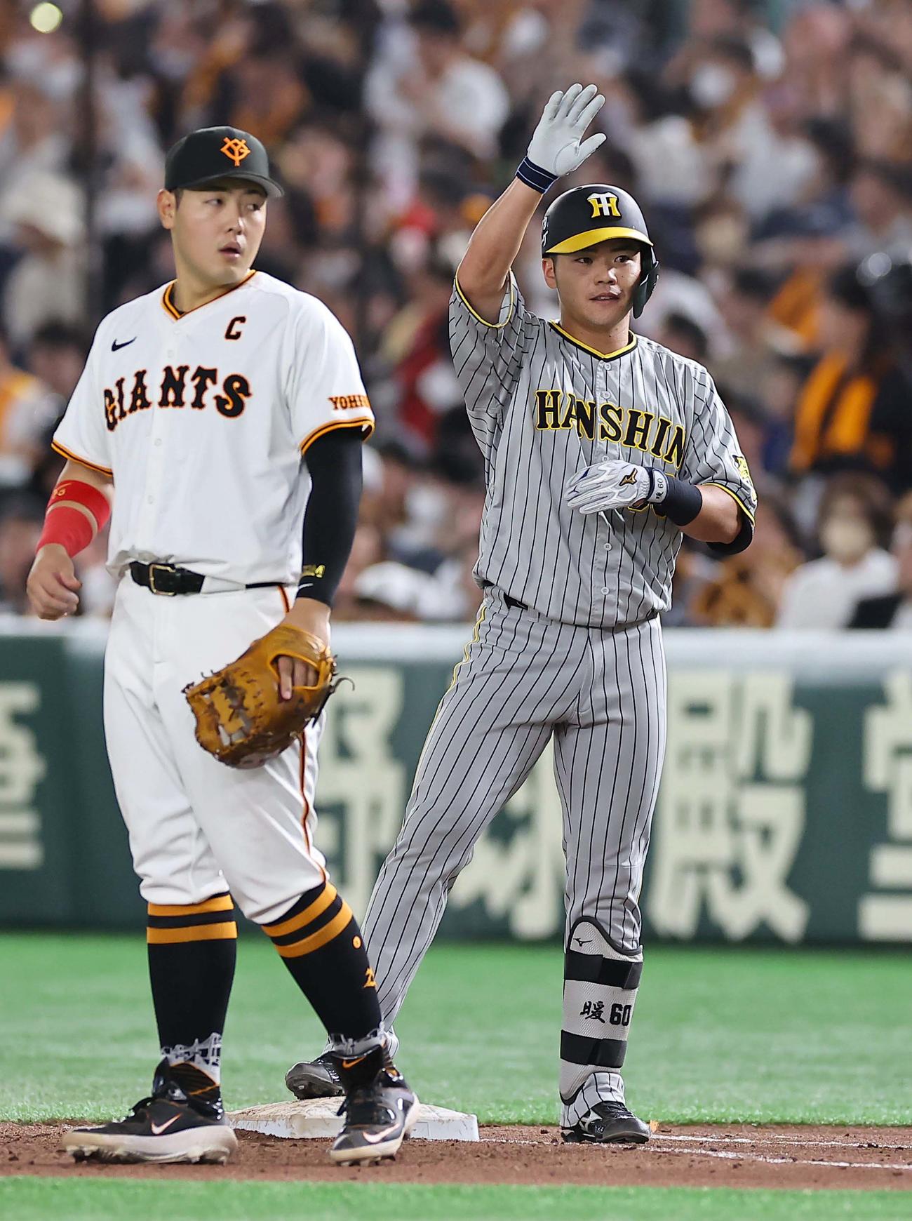 巨人対阪神　8回表阪神1死、小野寺（右）は右前打を放ち、一塁上で称賛に応える（撮影・上田博志）