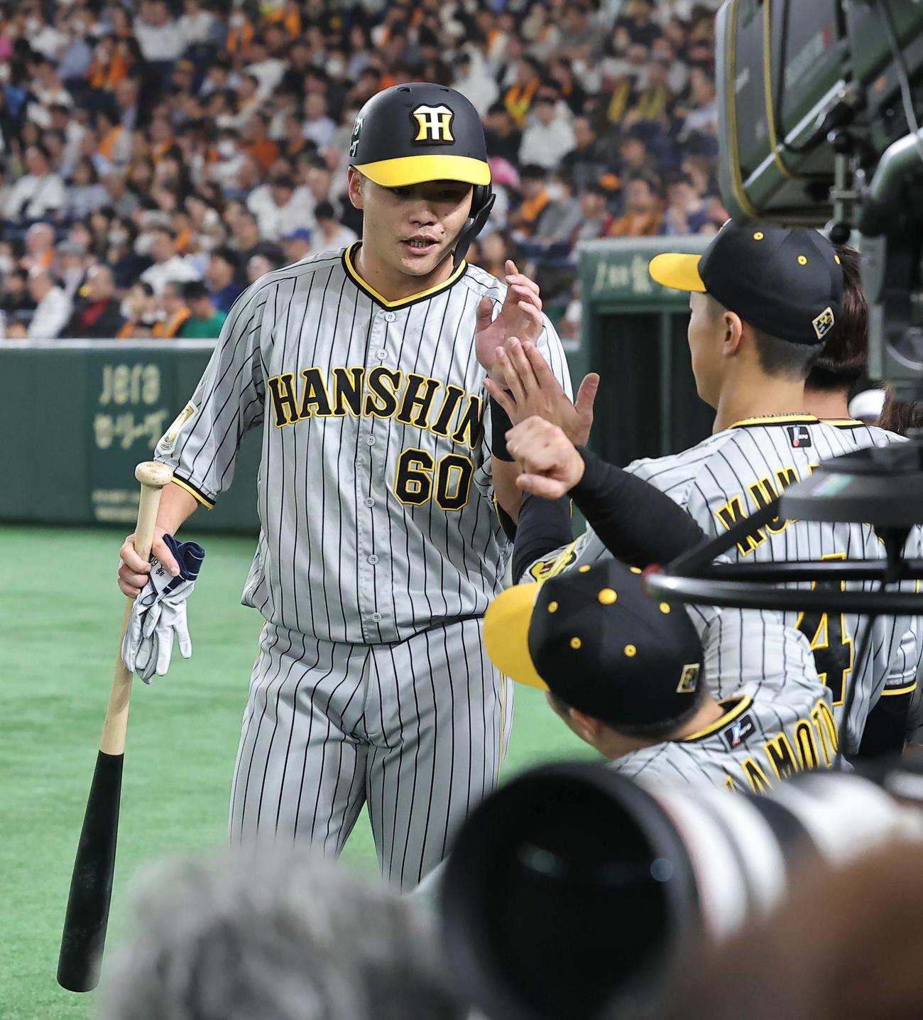 巨人対阪神　8回表阪神1死、代走を送られベンチに戻った小野寺はナインとハイタッチする（撮影・上田博志）