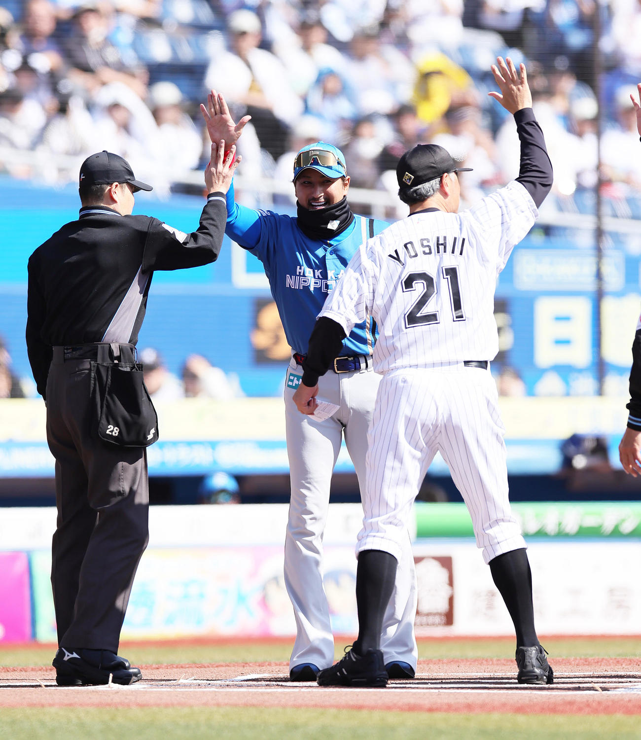 試合前のメンバー表交換でハイタッチを交わすロッテ吉井監督（右）と日本ハム新庄監督（中央）（撮影・足立雅史）