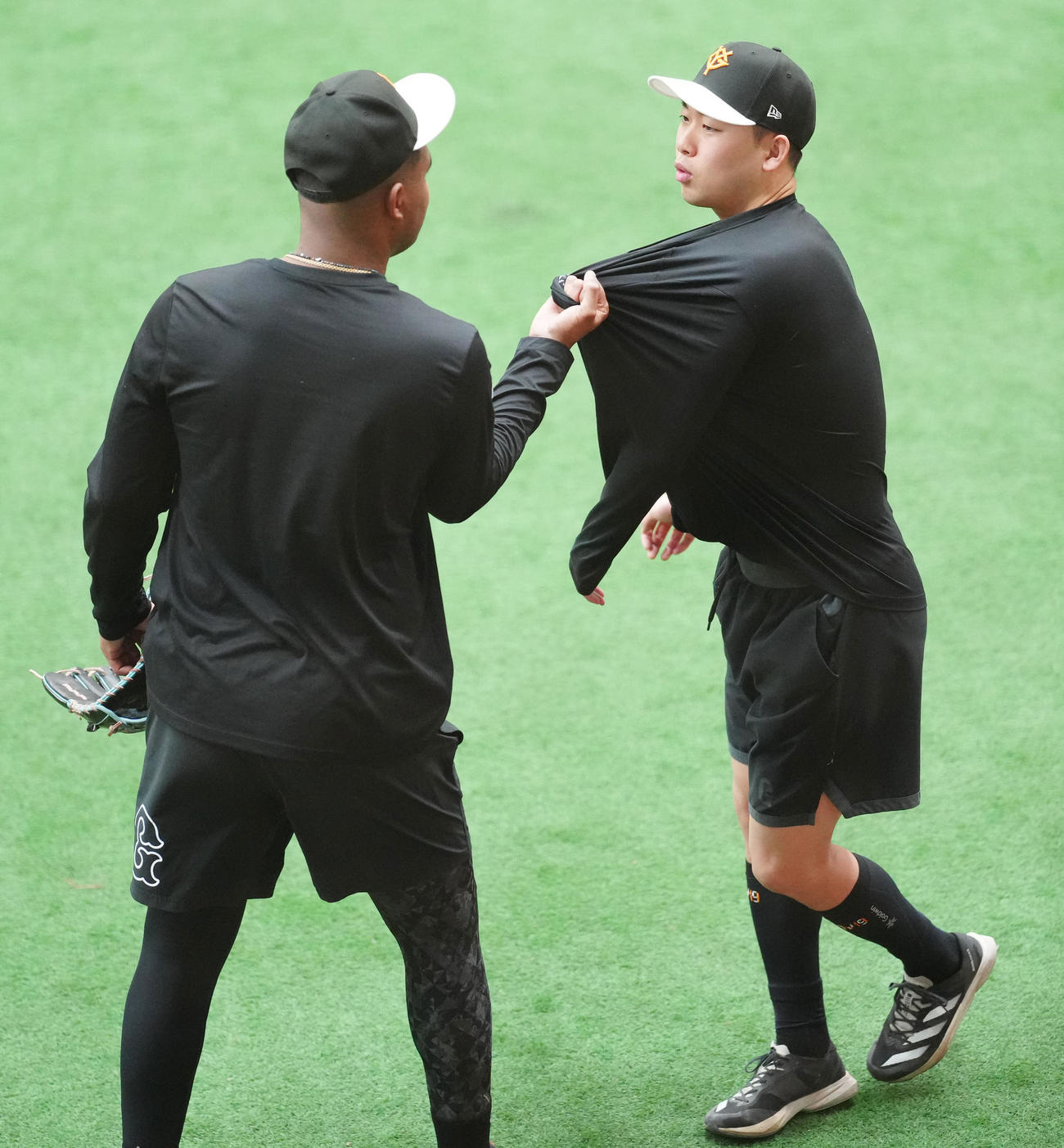 練習開始前、冗談で巨人メンデス（左）から胸ぐらをつかまれる山崎伊（撮影・江口和貴）