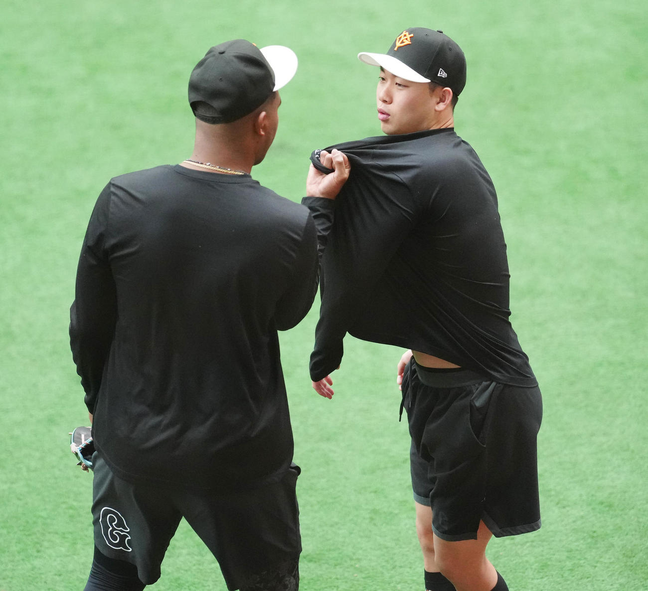 練習開始前、冗談で巨人メンデス（左）から胸ぐらをつかまれる山崎伊（撮影・江口和貴）
