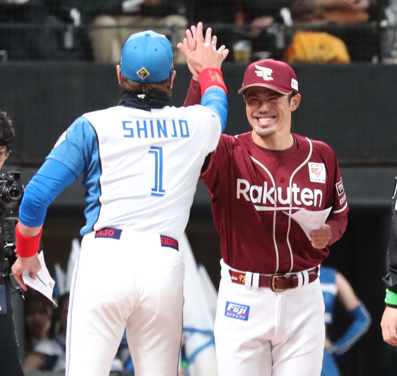 日本ハム対楽天　メンバー表交換でハイタッチする新庄監督と今江監督（撮影・黒川智章）