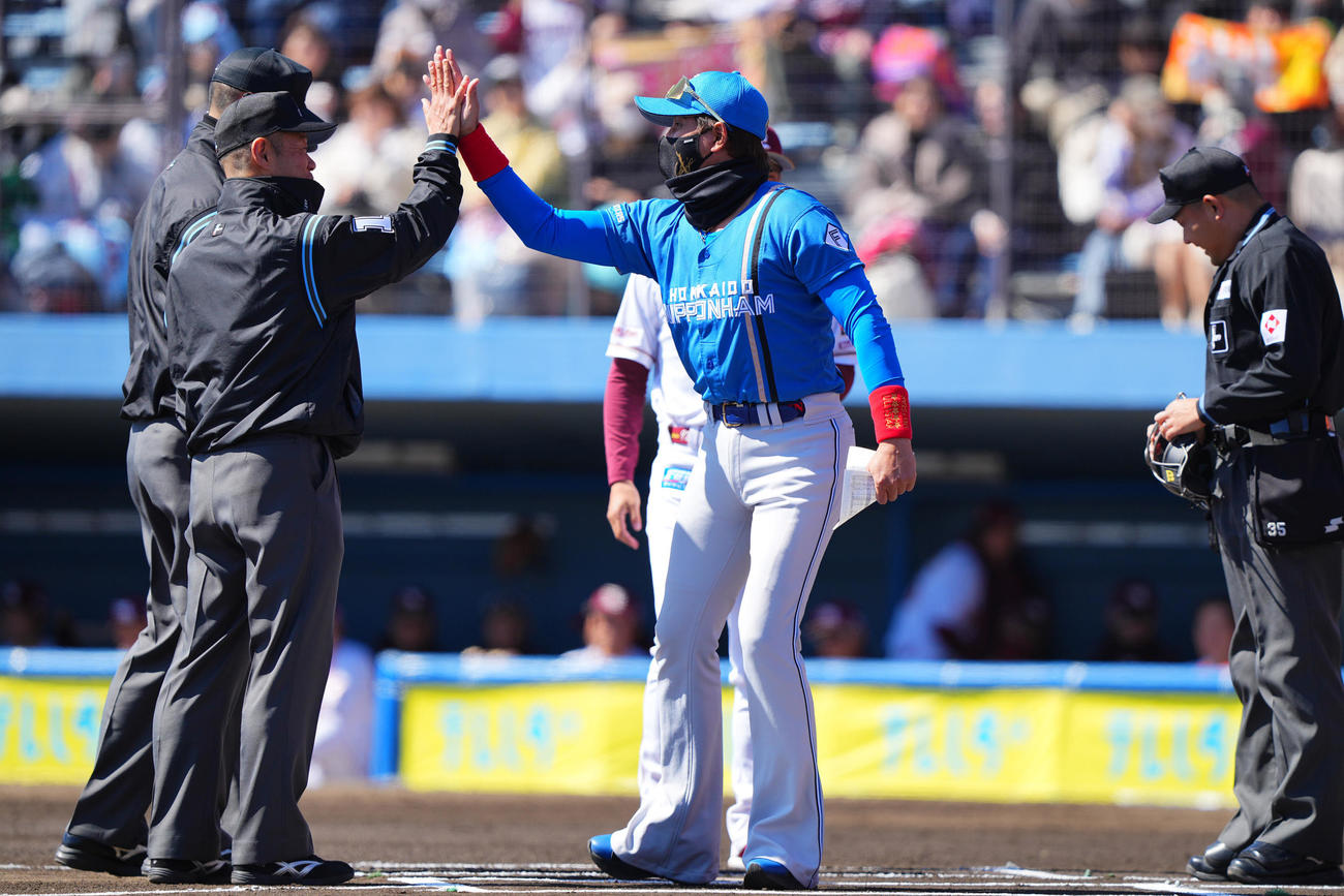 3月10日　楽天対日本ハム　試合前、メンバー表交換を行う審判団とハイタッチを交わす日本ハム新庄監督