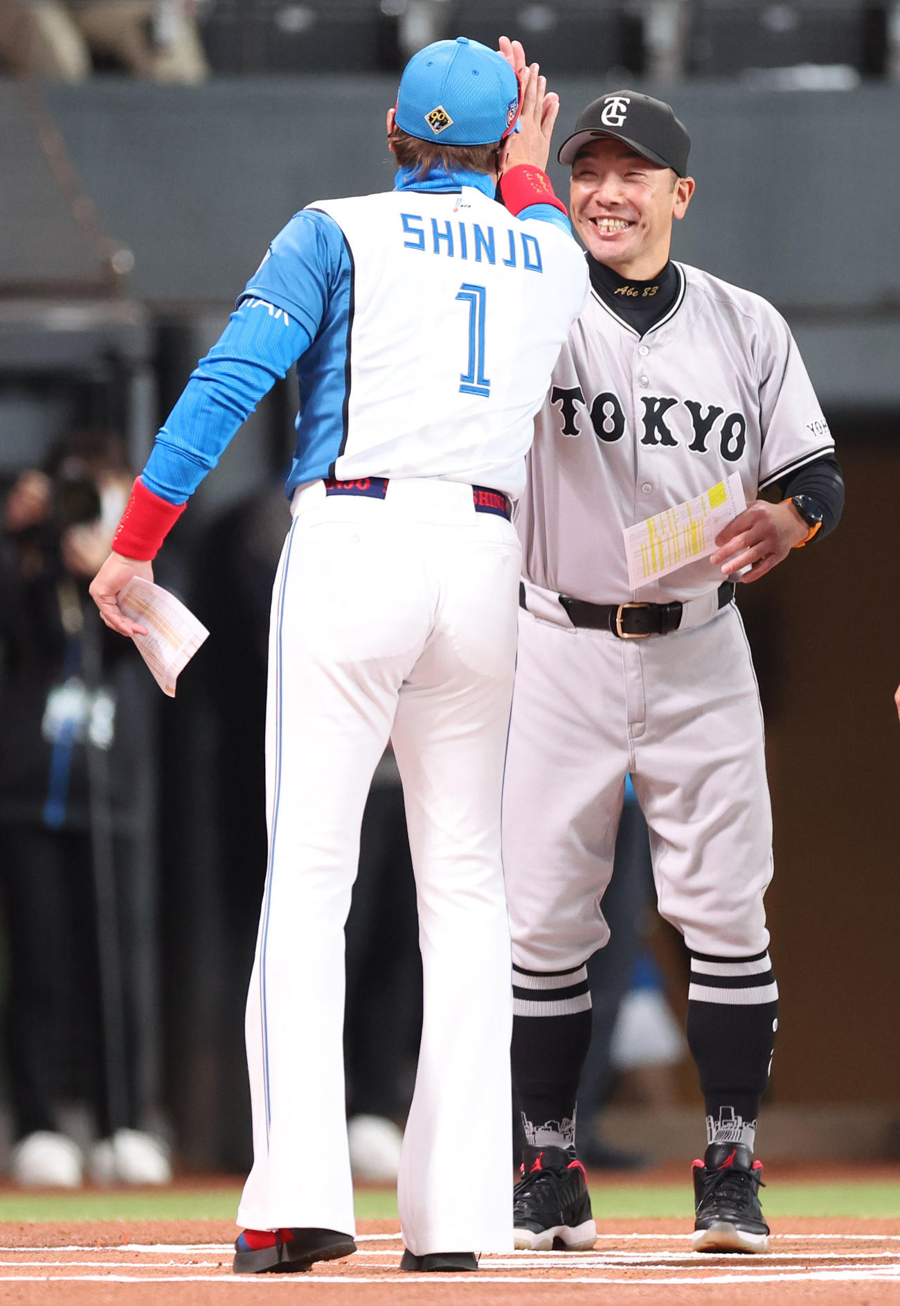 3月17日　日本ハム対巨人　試合前、メンバー表を交換しハイタッチをする日本ハム新庄監督（左手前）と巨人阿部監督
