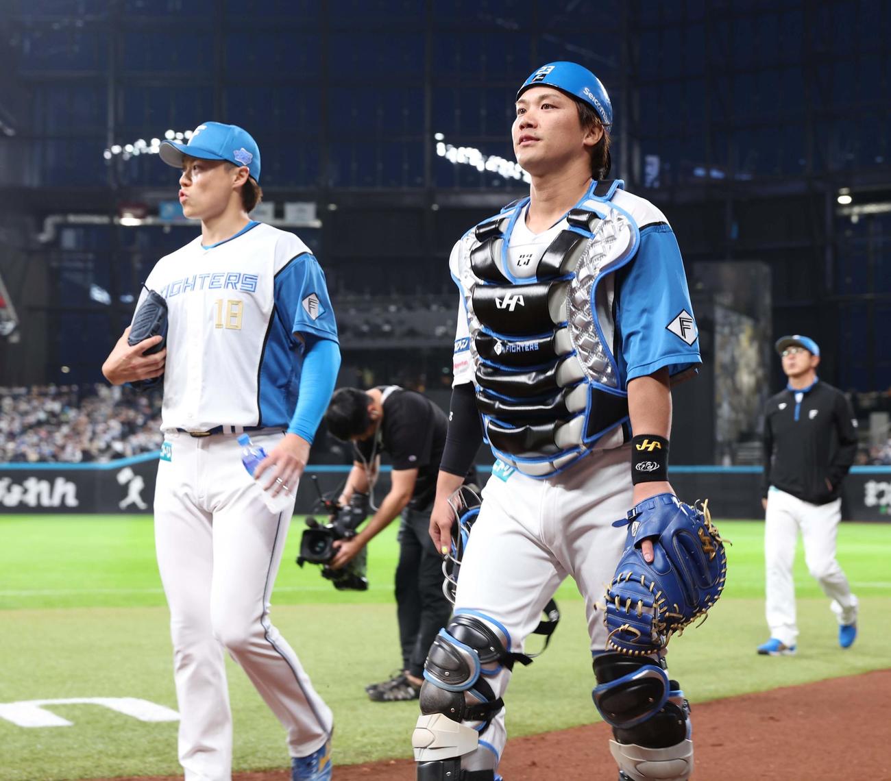 日本ハム対楽天　試合前の最終調整を終えベンチに戻る山崎（左）と伏見（撮影・黒川智章）