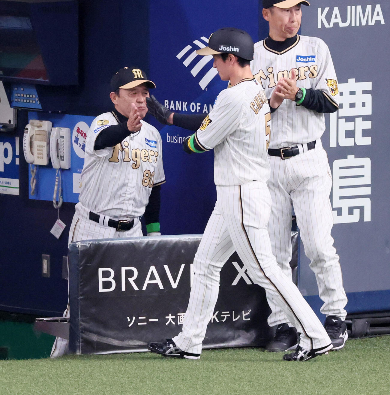 阪神対DeNA 1回裏阪神無死三塁、岡田監督（左）は中野の中適時打で生還した三塁走者近本とタッチ（撮影・加藤哉）