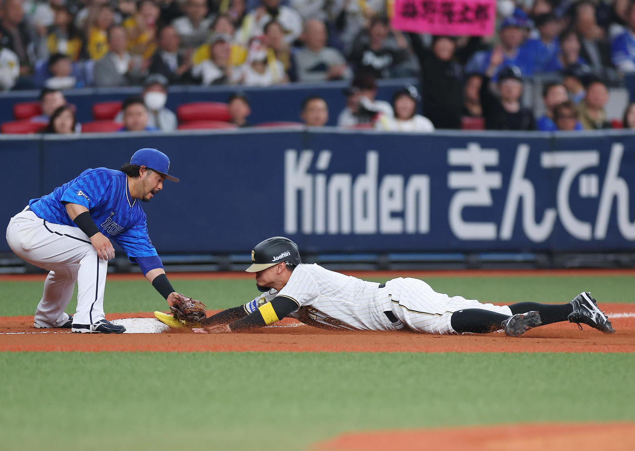 阪神対DeNA 4回裏阪神1死一、三塁、梅野の中前適時打で三進しヘッドスライディングする一走佐藤輝。三塁手宮崎（撮影・前田充）