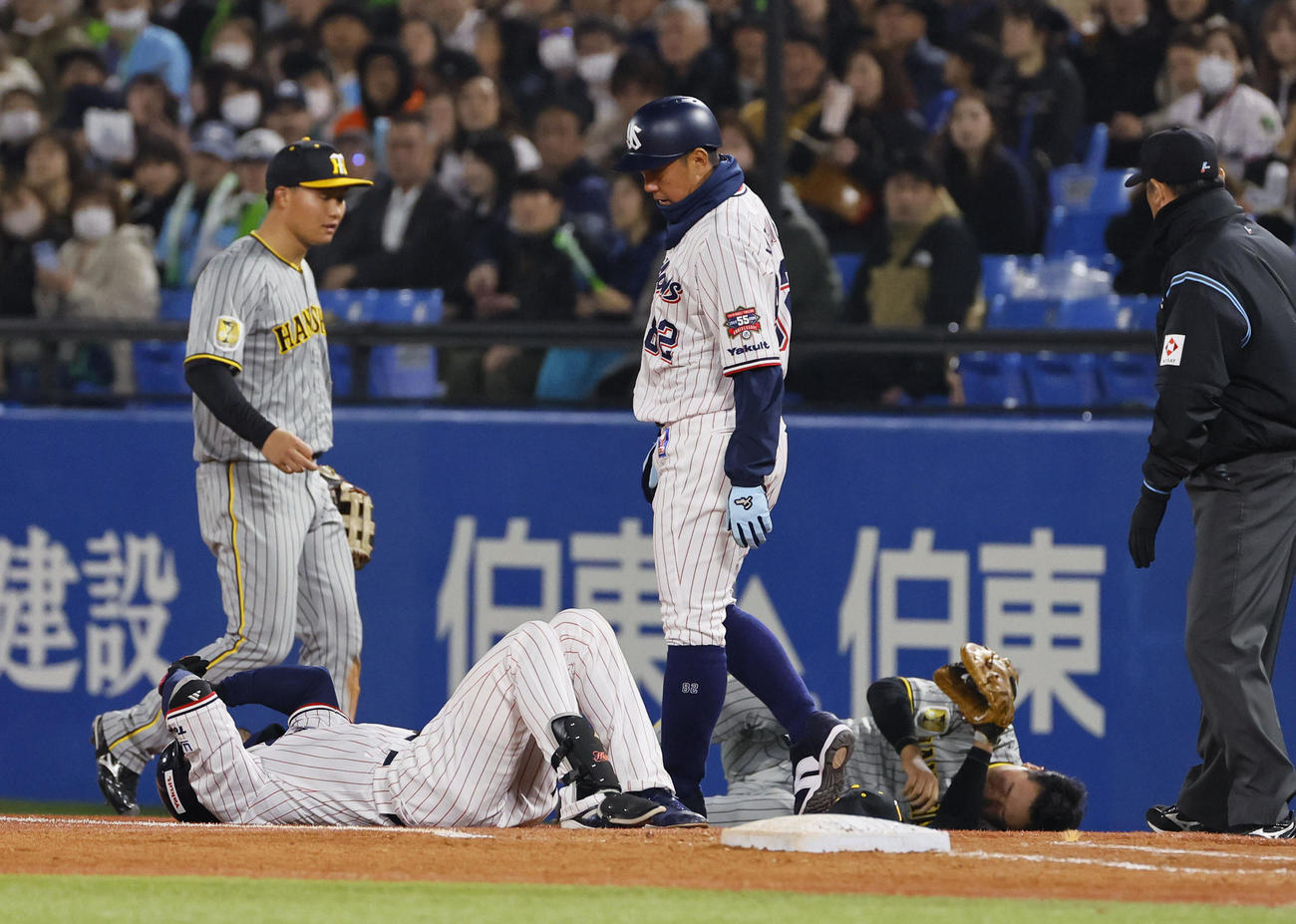 ヤクルト対阪神　5回裏ヤクルト無死、一塁上で激突し、倒れ込むヤクルト西川（左）と阪神大山（奥）（撮影・藤尾明華）