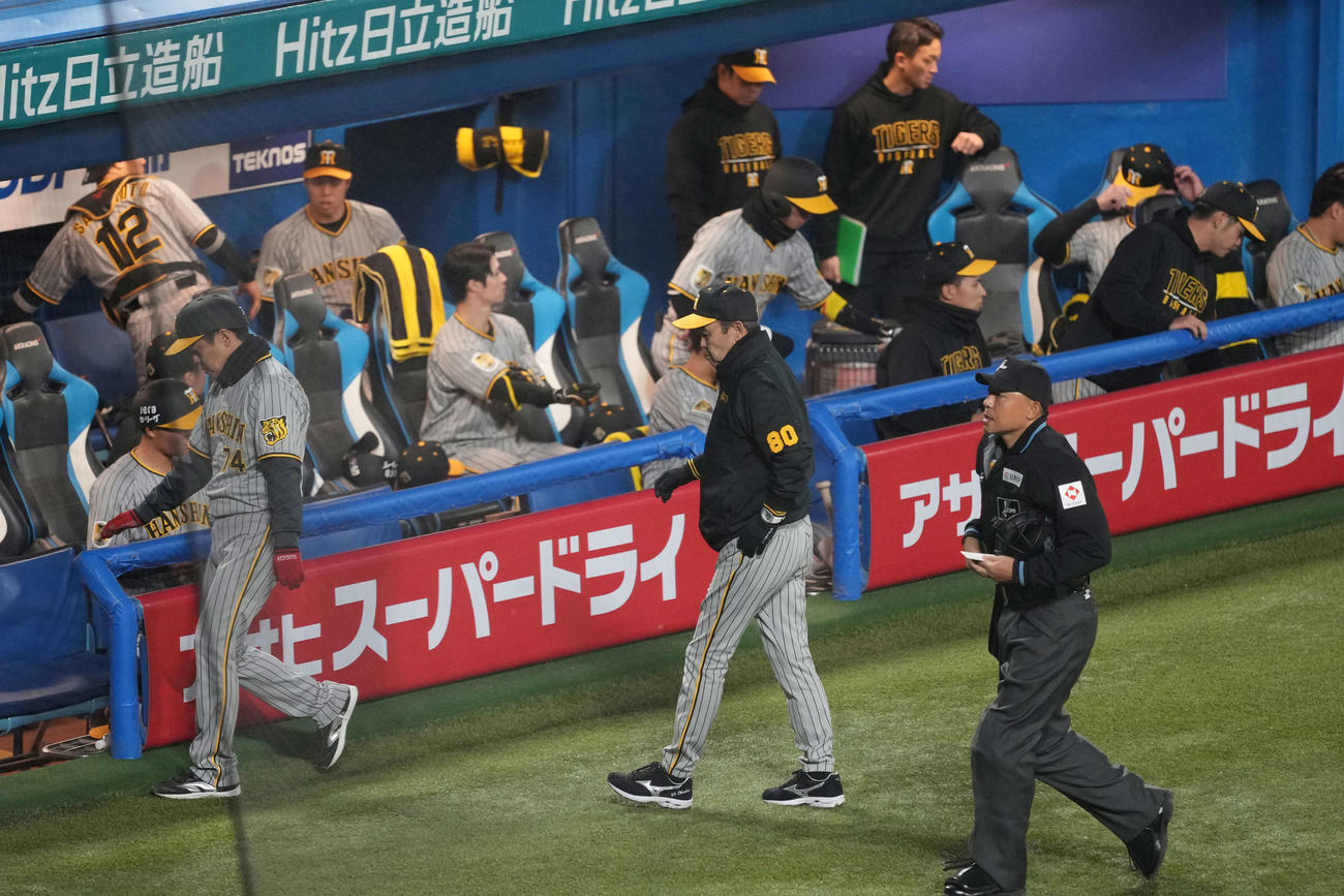 ヤクルト対阪神　7回、選手交代を告げベンチに戻る阪神岡田監督（中央）。後方左は青柳（撮影・井上学）