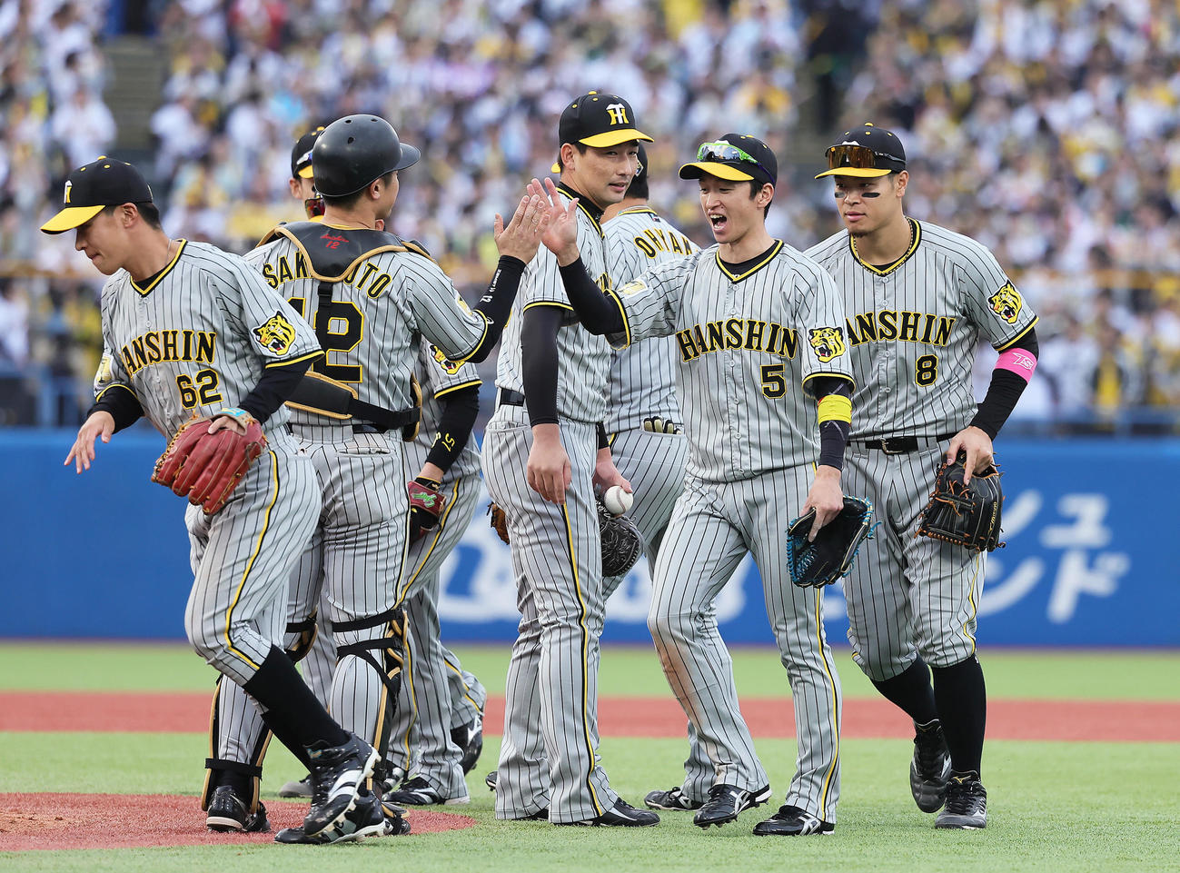 ヤクルト対阪神　ヤクルトに勝利しタッチを交わす阪神の、右から佐藤輝、近本ら（撮影・足立雅史）
