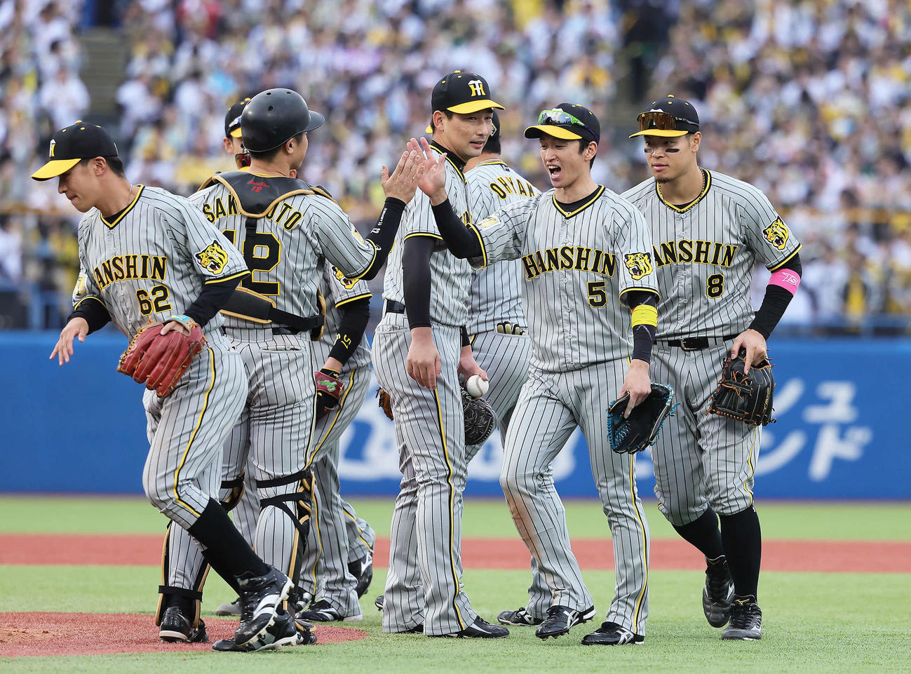 ヤクルト対阪神　ヤクルトに勝利しタッチを交わす阪神の、右から佐藤輝、近本ら（撮影・足立雅史）