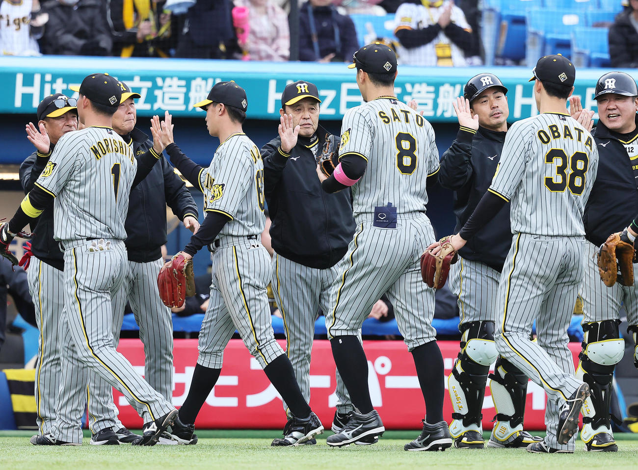 ヤクルト対阪神　ヤクルトに勝利した阪神岡田監督（中央）は佐藤輝（同右）らをタッチで迎える（撮影・足立雅史）