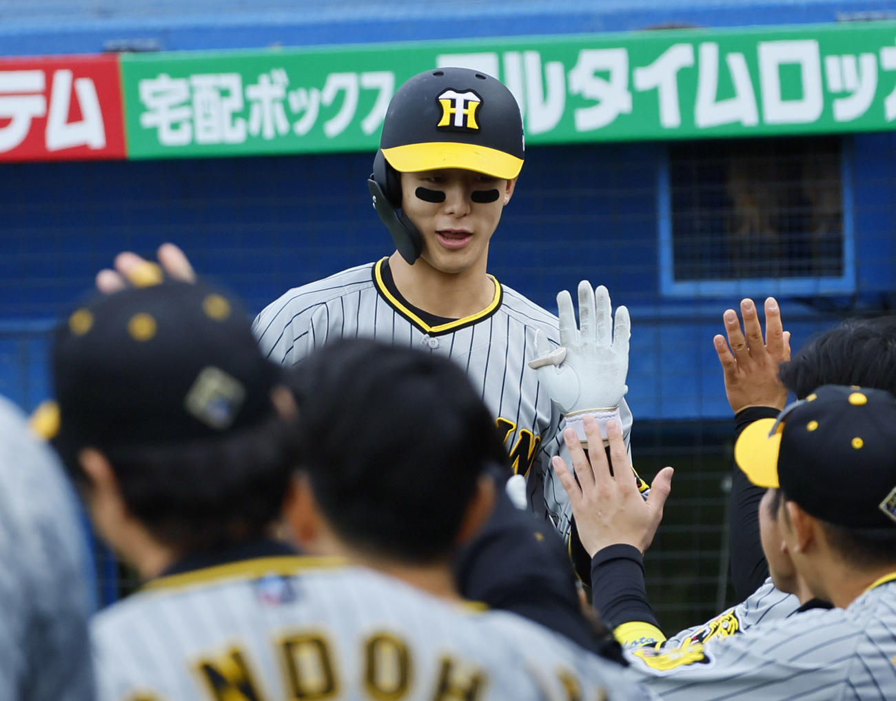 ヤクルト対阪神　7回表阪神無死一塁、犠打を決め、ナインとタッチを交わす小幡（撮影・藤尾明華）