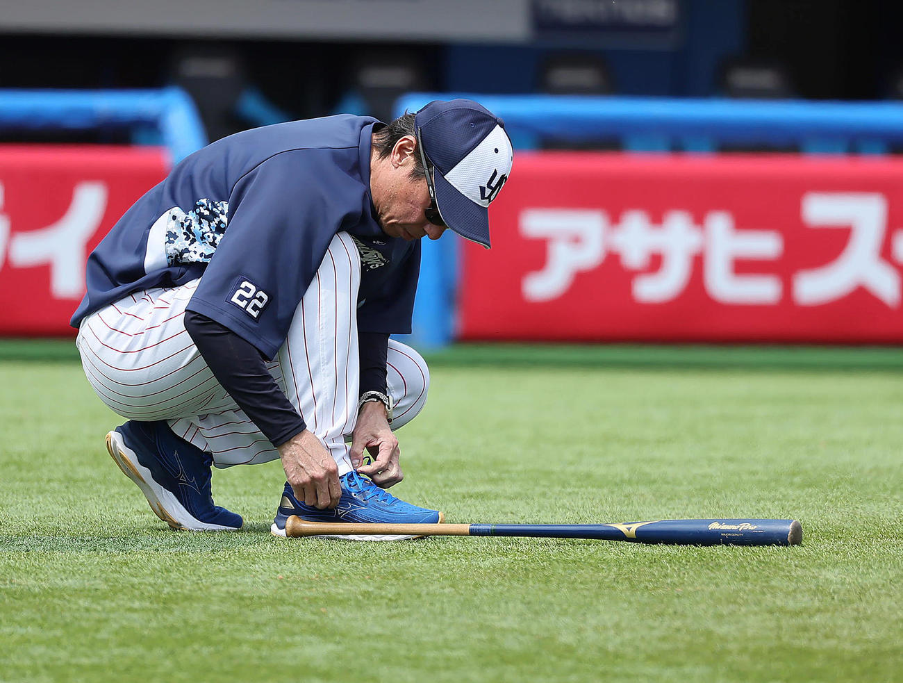 練習中、靴ひもを結び直すヤクルト高津監督（撮影・足立雅史）