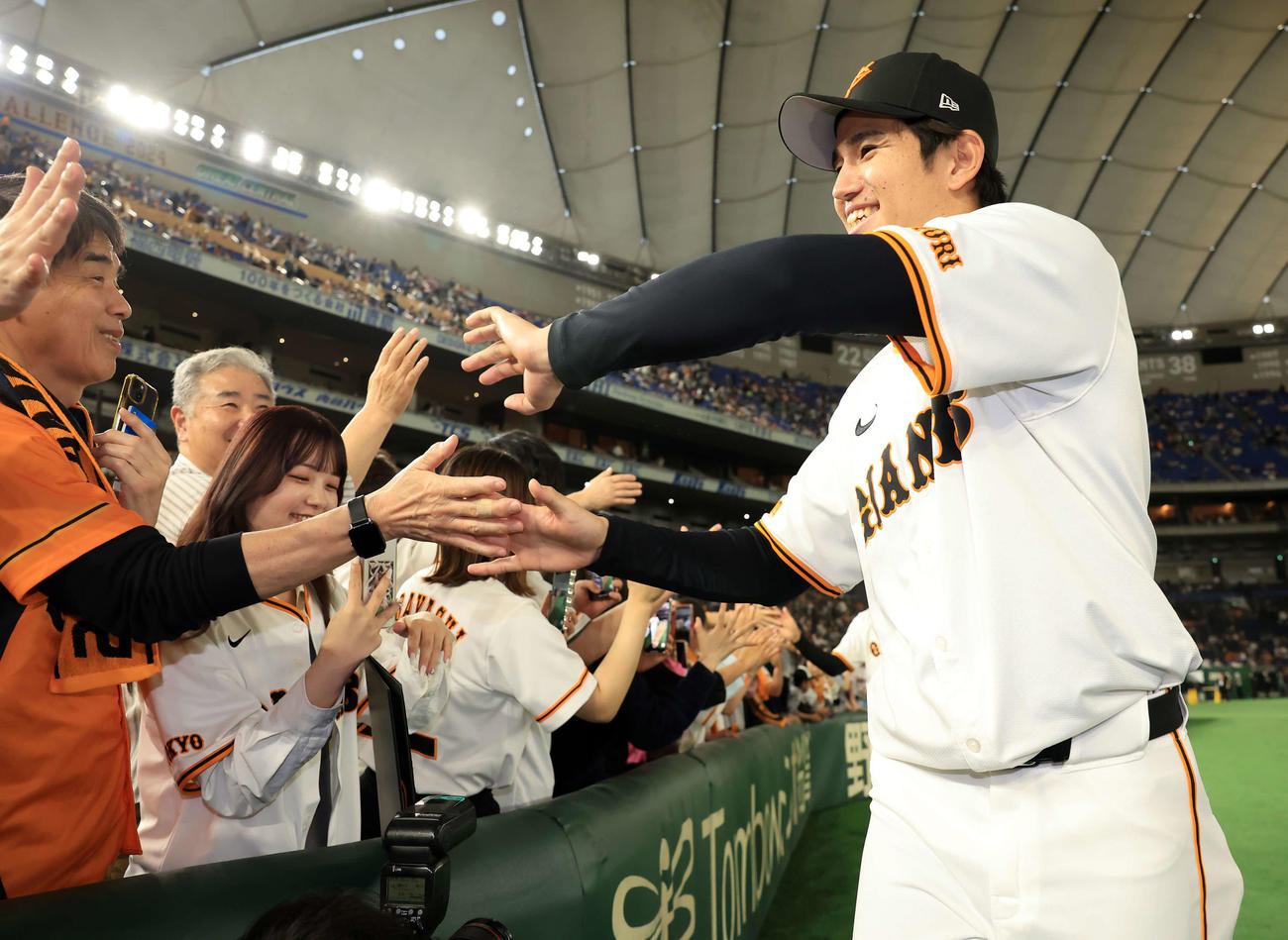 巨人対DeNA　移籍後初勝利の巨人高橋礼（右）は笑顔でファンとハイタッチ（撮影・浅見桂子）