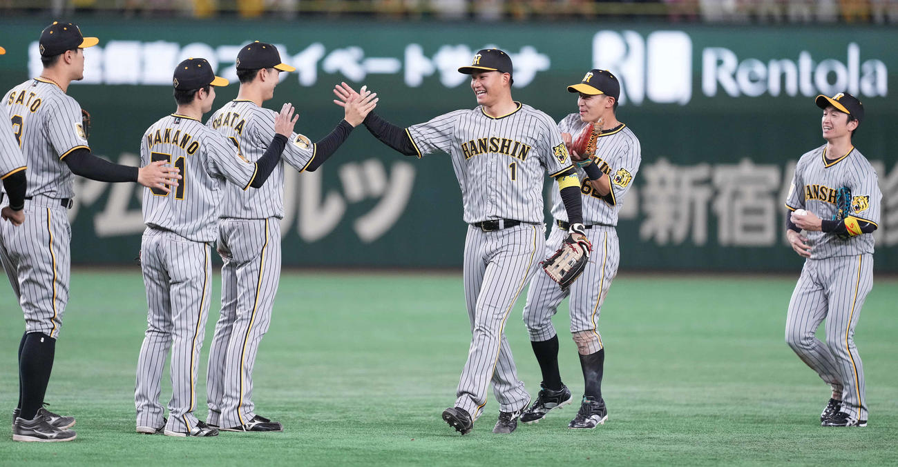 3月31日、巨人対阪神　巨人に勝利し、タッチを交わす森下（中央）ら阪神ナイン、右端は勝利球を手にする近本
